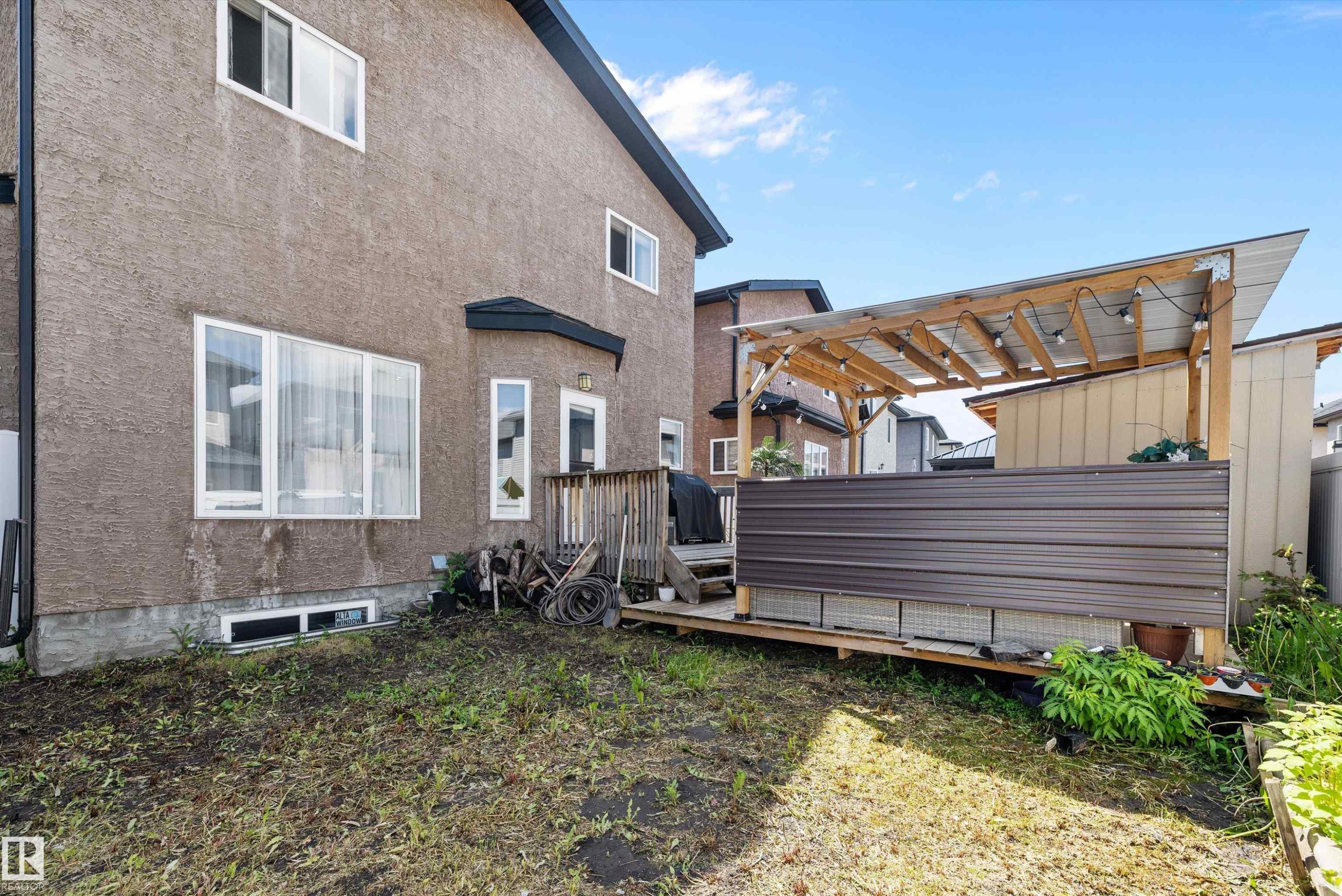 Rear exterior featuring a stucco facade and multiple windows - 16742 61 Street, Edmonton, AB