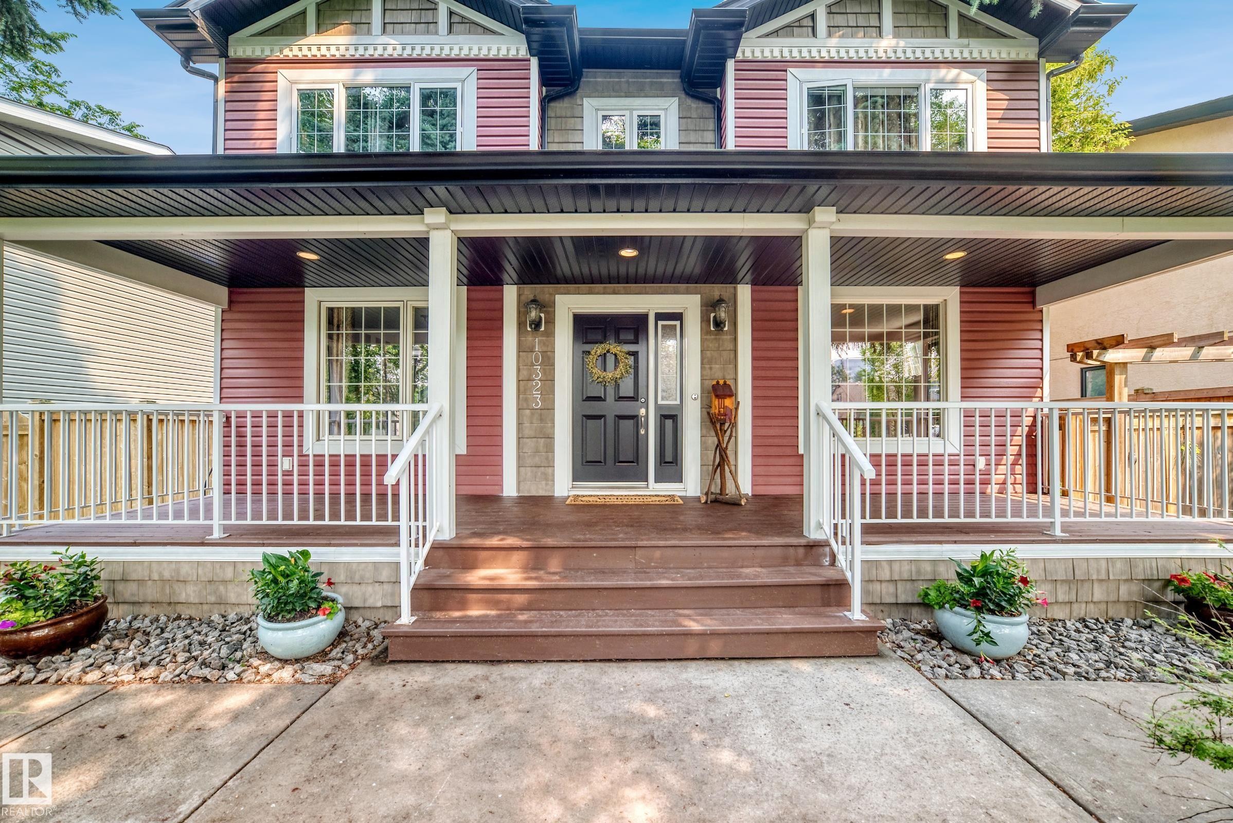Covered front porch with wood-finish steps and railing - 10323 138 Street Nw, Edmonton, AB - Outdoor With Deck Patio Veranda