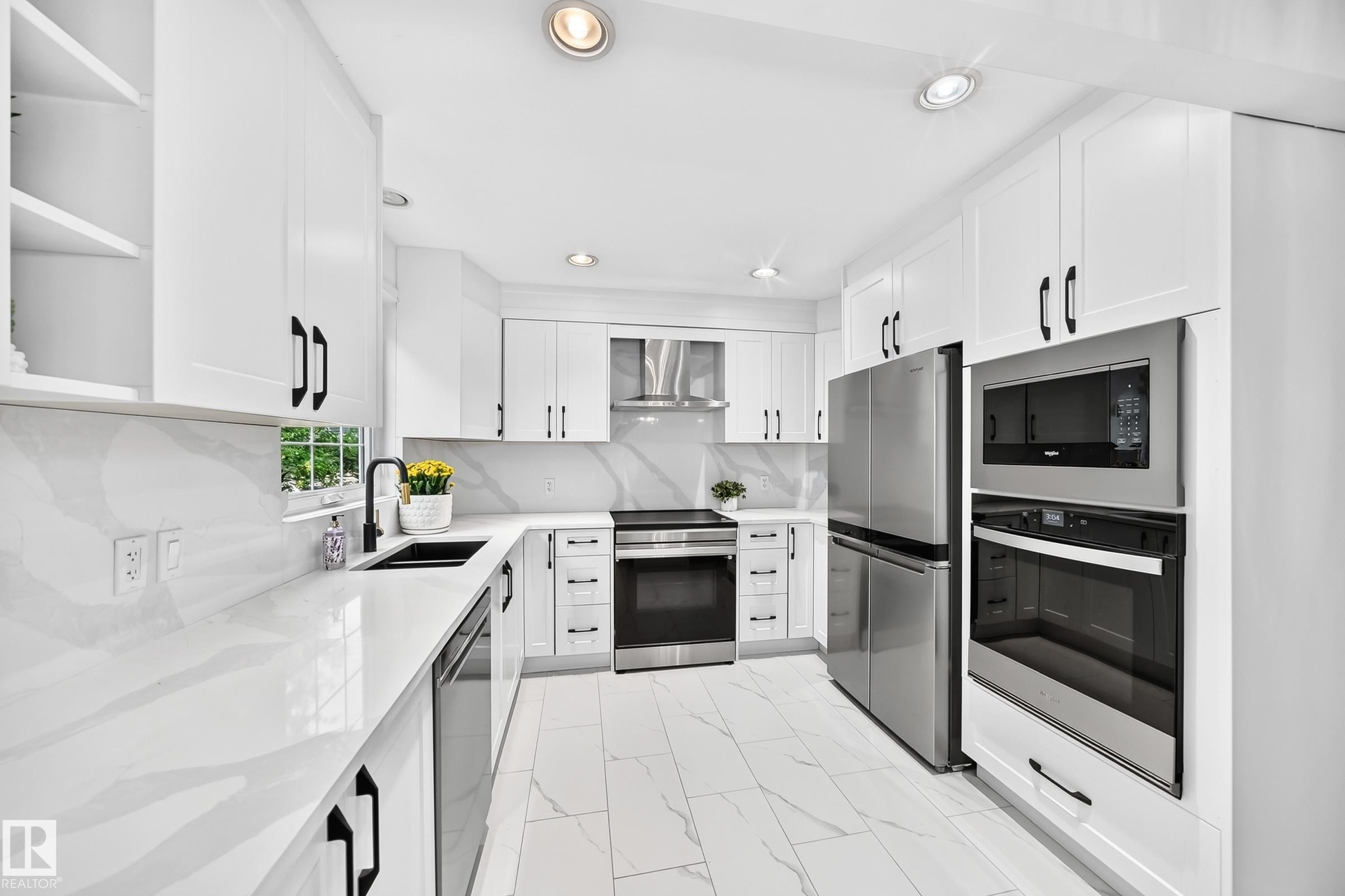 Contemporary kitchen featuring white cabinetry, integrated stainless steel appliances, marble-look countertops, a black undermount sink with a matching faucet, and recessed lighting - 10323 138 Street Nw, Edmonton, AB - Indoor Photo Showing Kitchen With Double Sink With Upgraded Kitchen