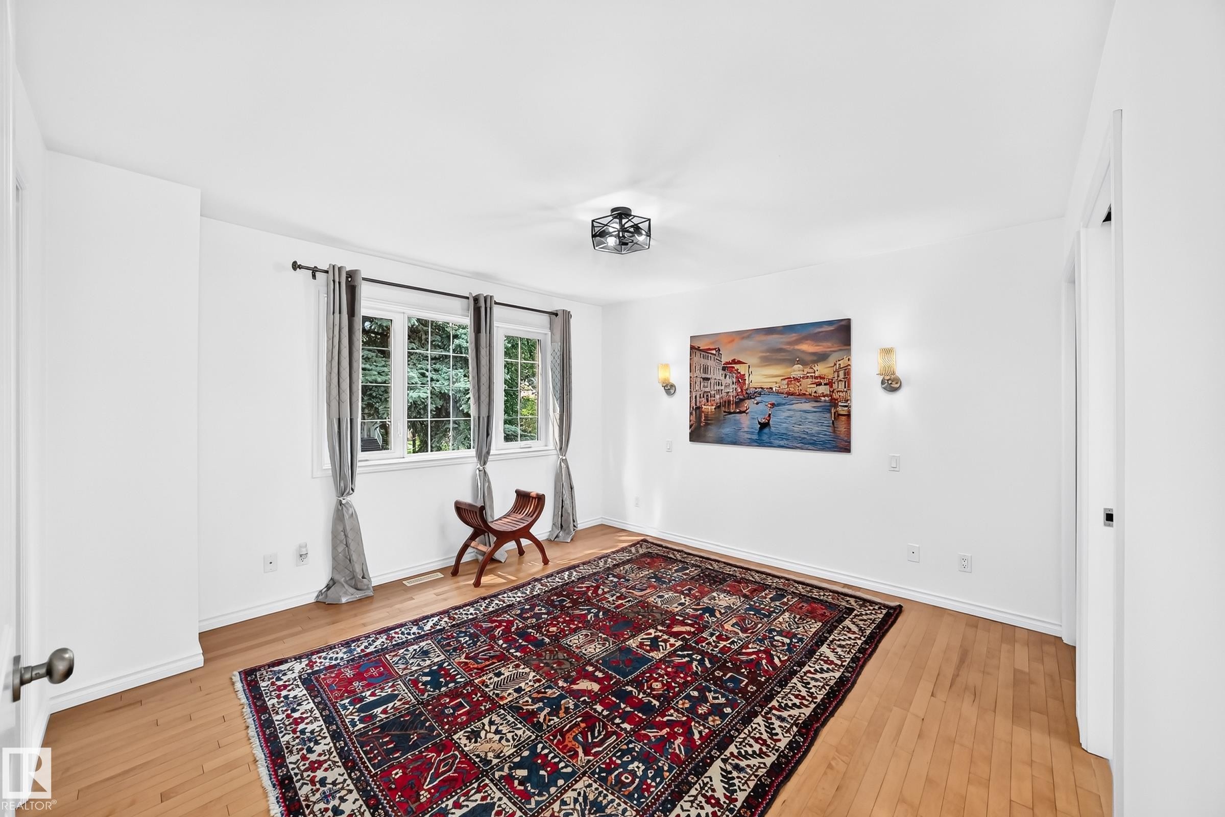 Bright room featuring light wood-finish flooring, white walls, and a multi-pane window with dark drapery rods - 10323 138 Street Nw, Edmonton, AB - Indoor Photo Showing Other Room