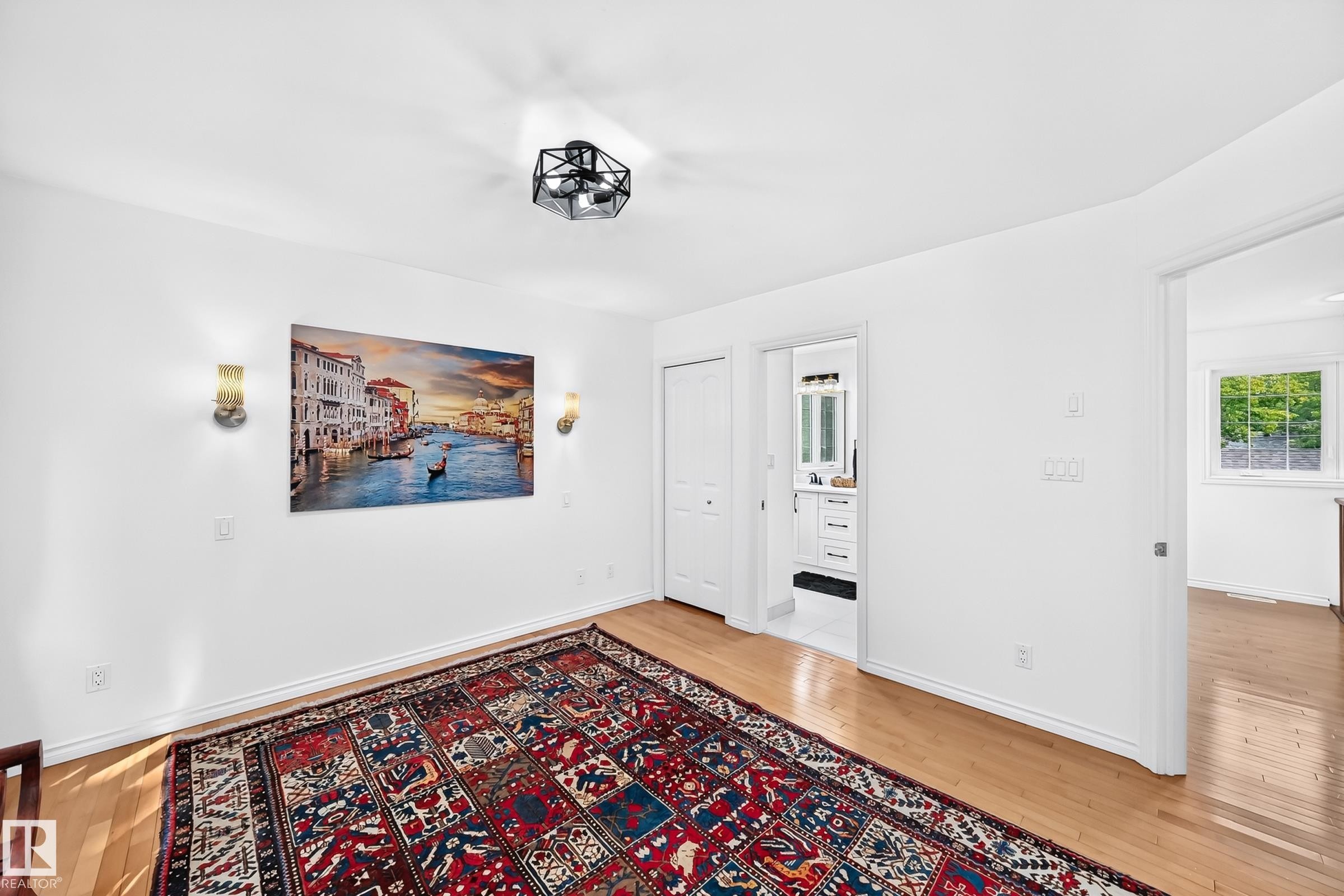 Light wood-finish flooring complements white walls - 10323 138 Street Nw, Edmonton, AB - Indoor Photo Showing Other Room