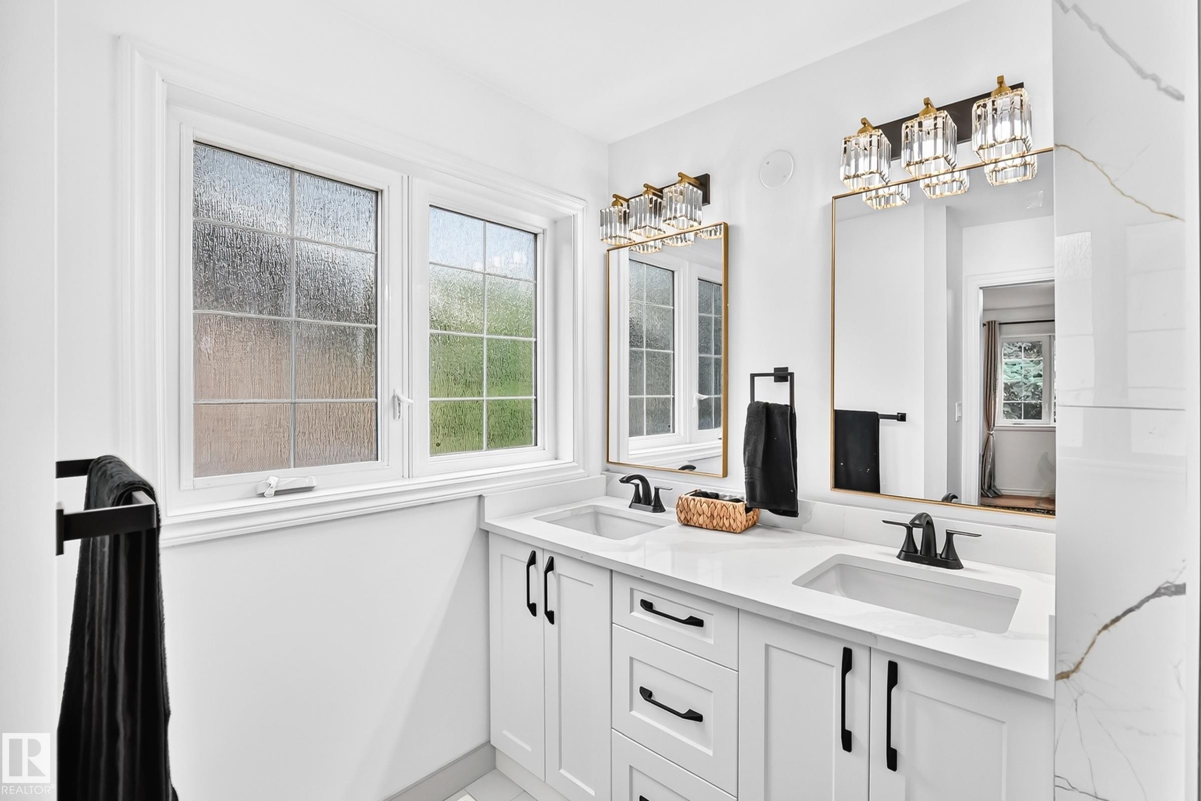 Double vanity featuring white shaker-style cabinetry, white countertops, and integrated rectangular sinks - 10323 138 Street Nw, Edmonton, AB - Indoor Photo Showing Bathroom