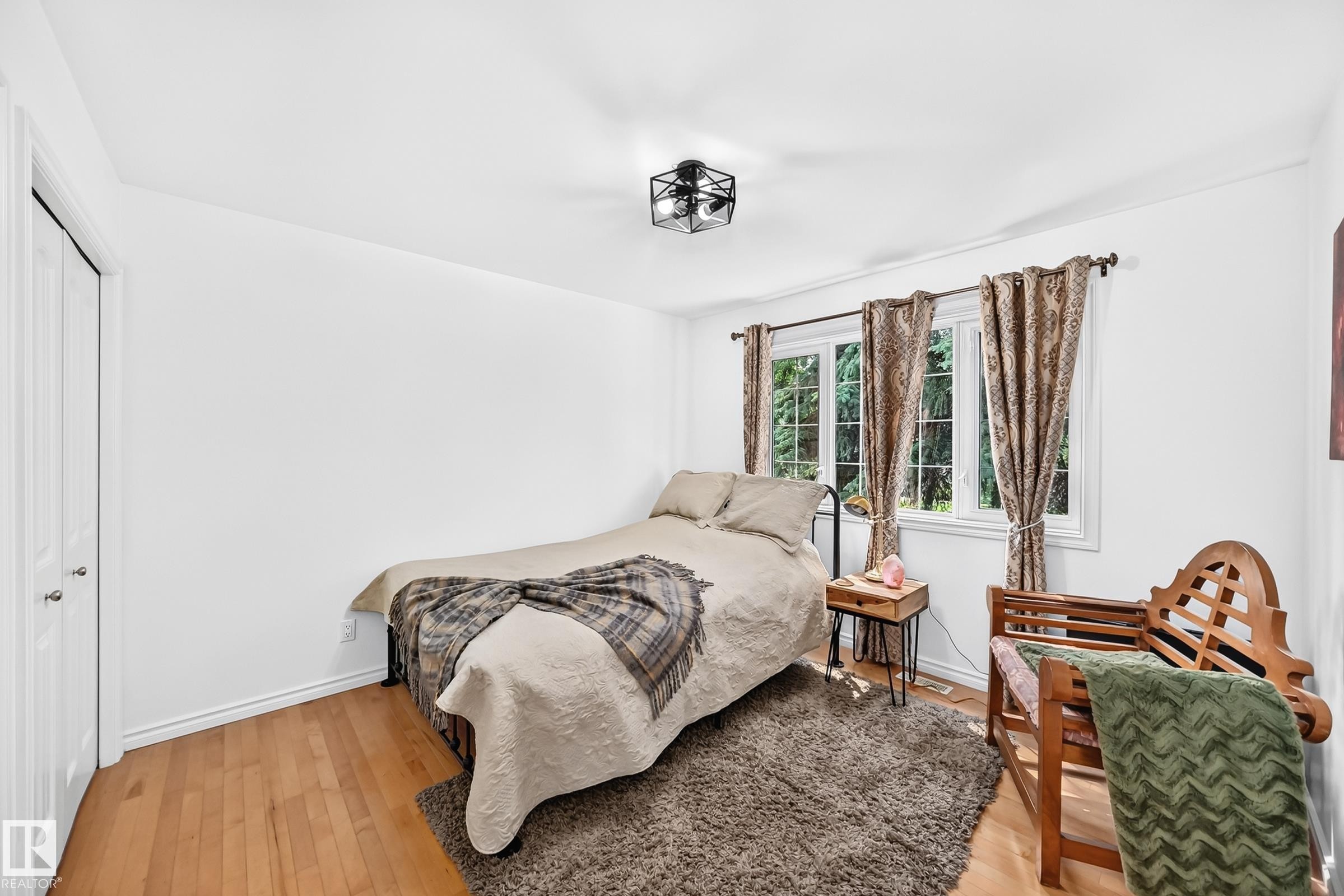 Bright interior space featuring wood-finish flooring and white walls - 10323 138 Street Nw, Edmonton, AB - Indoor Photo Showing Bedroom