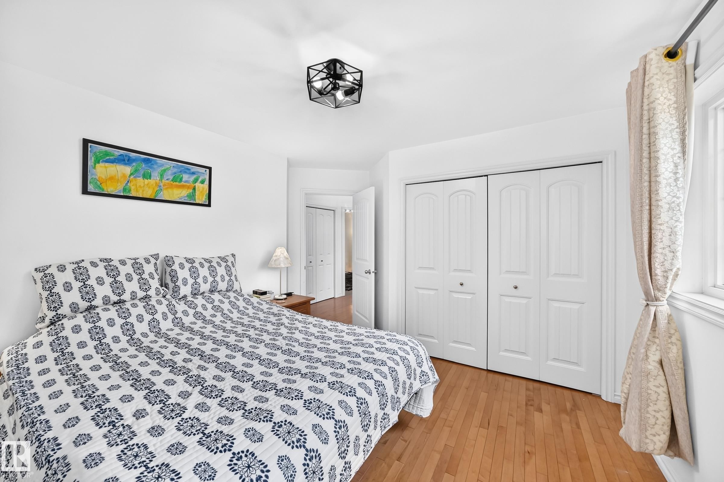 Bedroom featuring light wood-finish flooring, white walls, and a contemporary ceiling fixture - 10323 138 Street Nw, Edmonton, AB - Indoor Photo Showing Bedroom