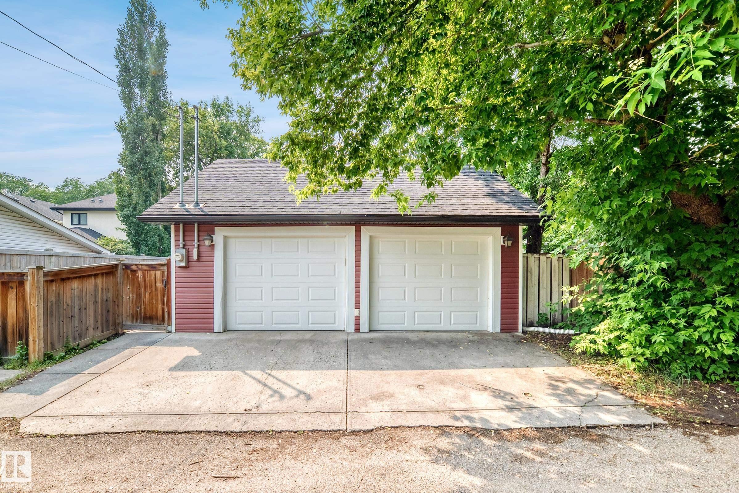 Detached two-car garage with white panel doors and red siding - 10323 138 Street Nw, Edmonton, AB - Outdoor
