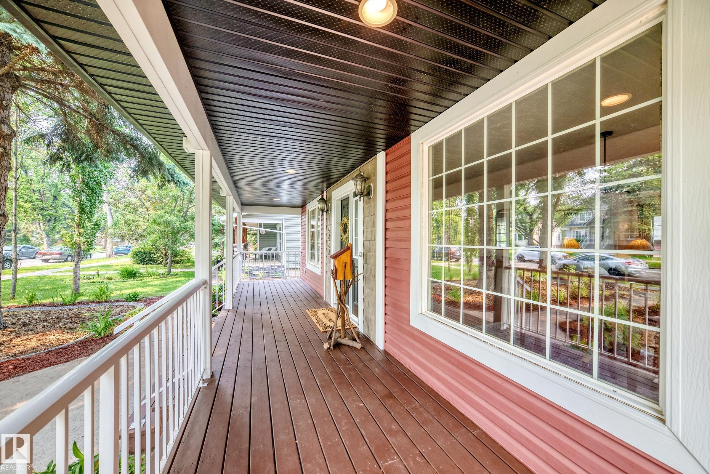 Inviting covered front porch with rich wood-finish decking - 10323 138 Street Nw, Edmonton, AB - Outdoor With Exterior