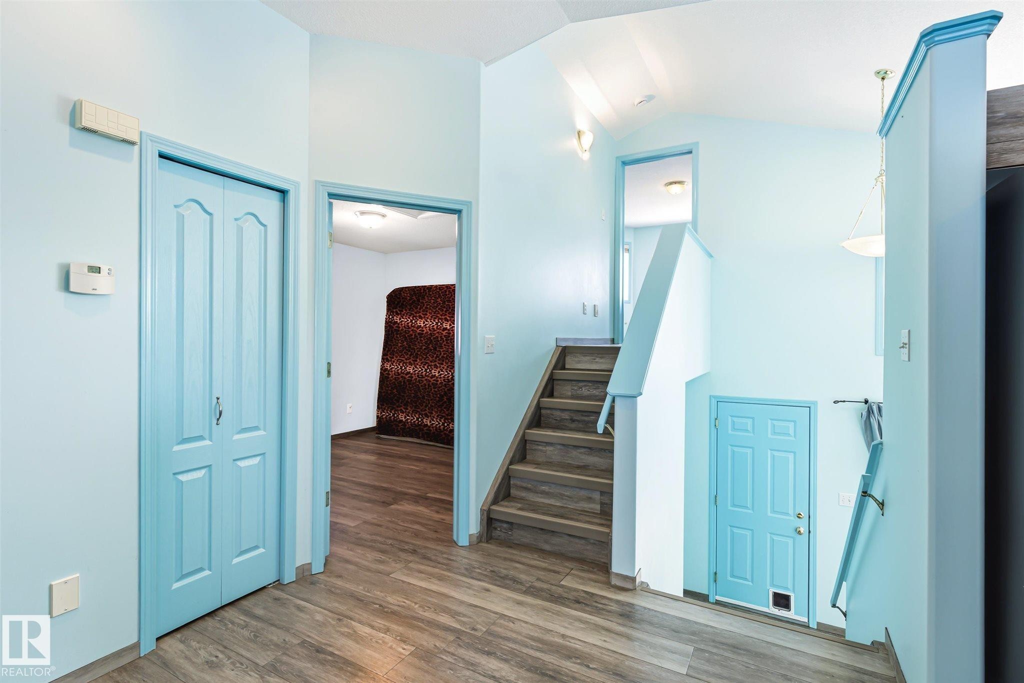 Interior staircase featuring wood-finish treads and a light blue banister - 14908 137 Street Nw, Edmonton, AB - Indoor Photo Showing Other Room