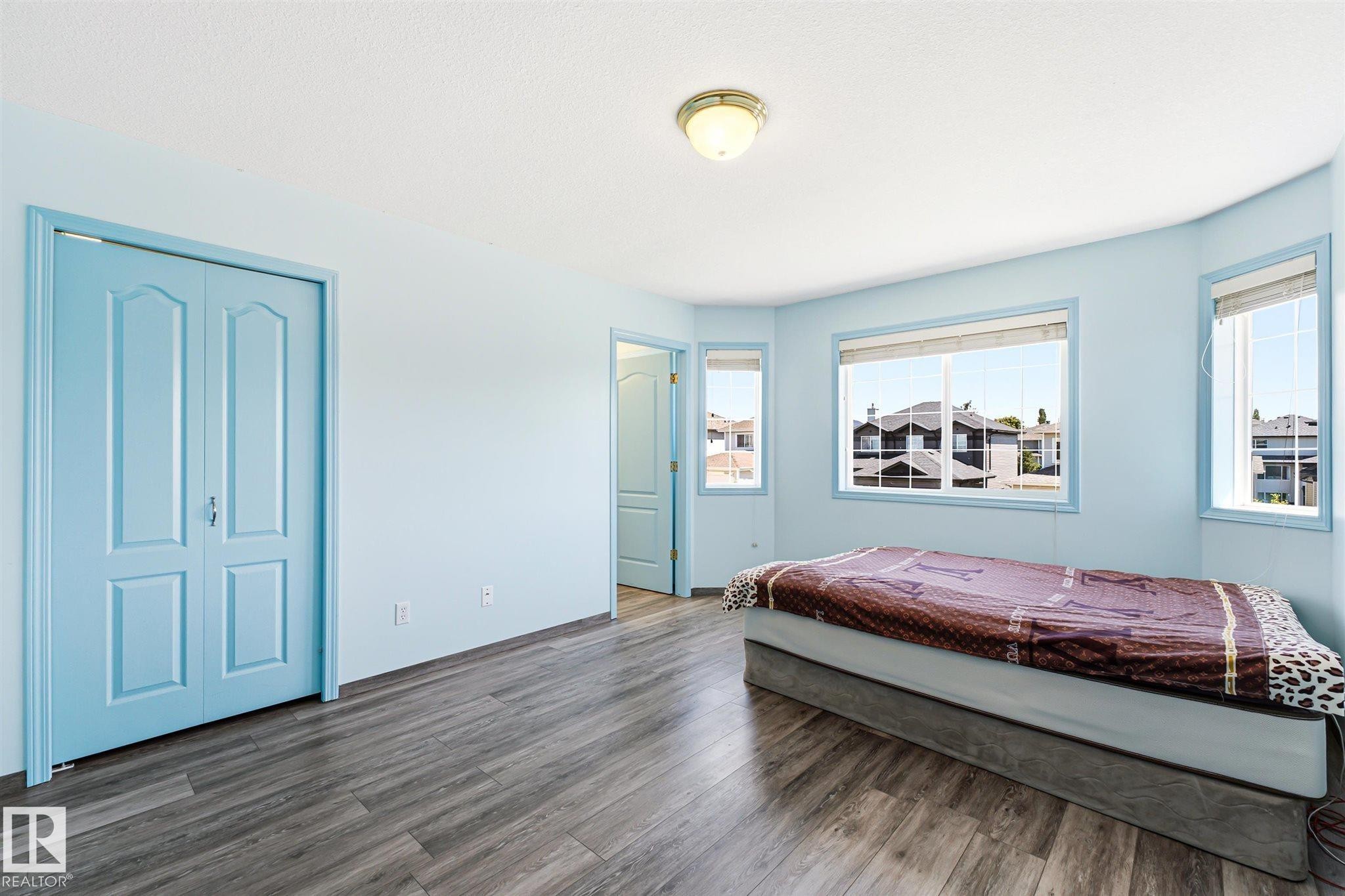 Room featuring wood-finish flooring and a light blue color palette - 14908 137 Street Nw, Edmonton, AB - Indoor Photo Showing Bedroom