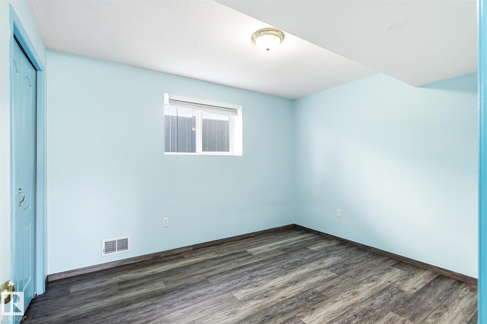 Room with wood-finish flooring, light blue walls, and a white ceiling - 14908 137 Street Nw, Edmonton, AB - Indoor Photo Showing Other Room