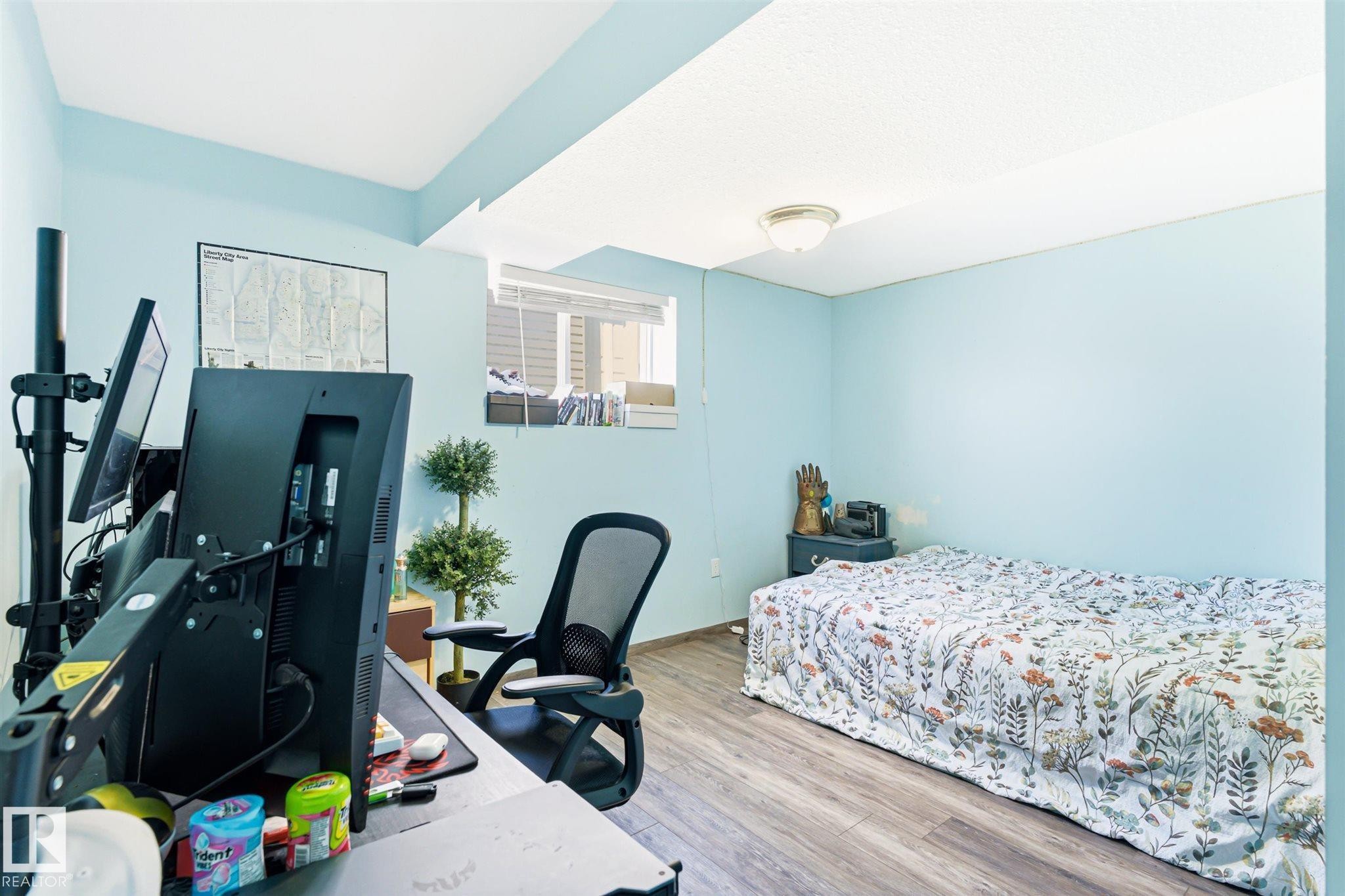 Versatile room featuring wood-finish flooring, a window offering natural light, and a flush-mount ceiling light fixture - 14908 137 Street Nw, Edmonton, AB - Indoor Photo Showing Bedroom