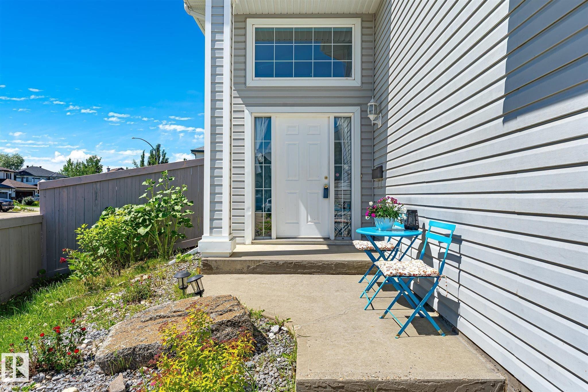 Entryway featuring a white paneled door with sidelight, transom window, and light grey horizontal siding - 14908 137 Street Nw, Edmonton, AB - Outdoor