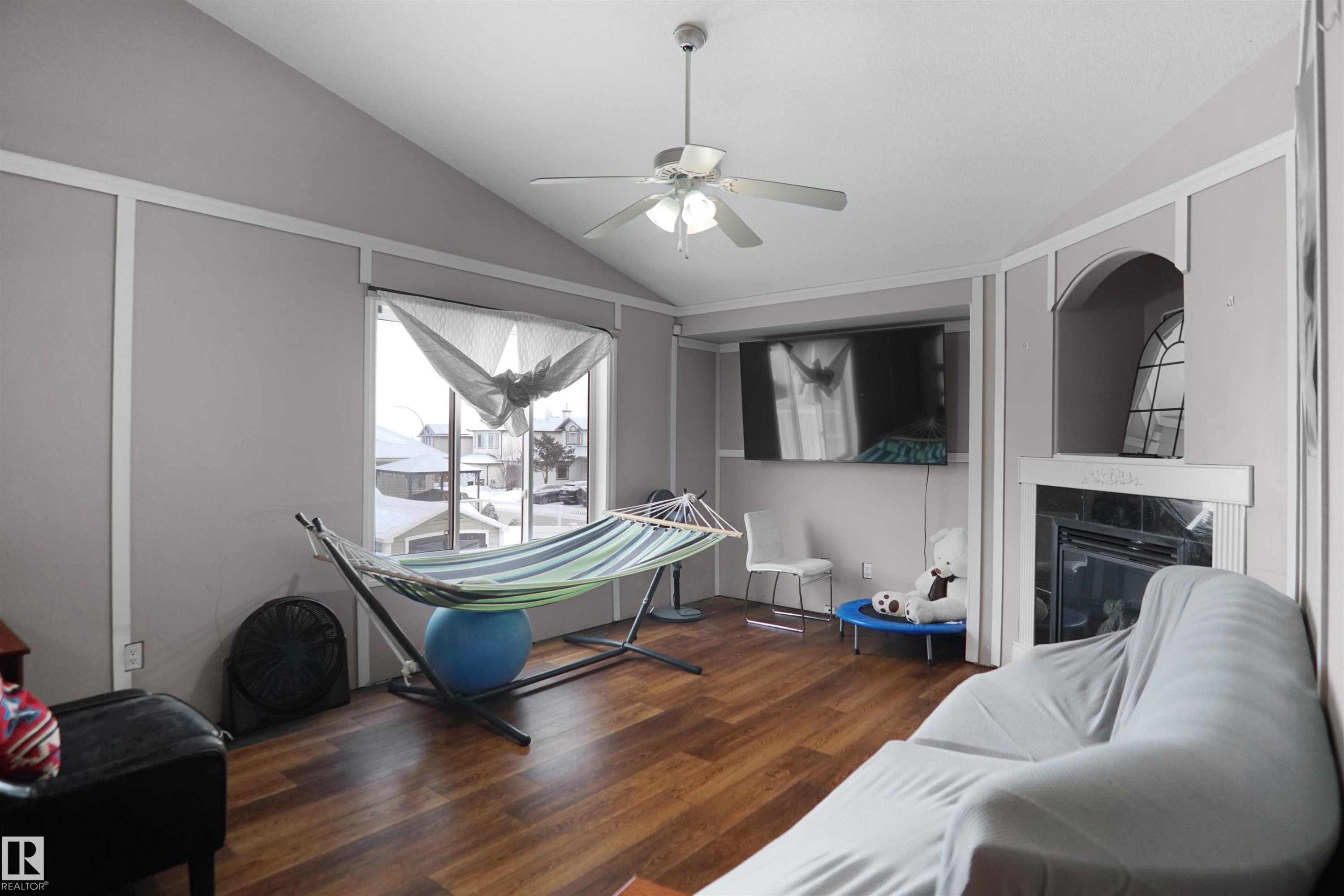 Living area featuring wood-finish flooring, a vaulted ceiling, and a ceiling fan - 4816 155 Ave, Edmonton, AB