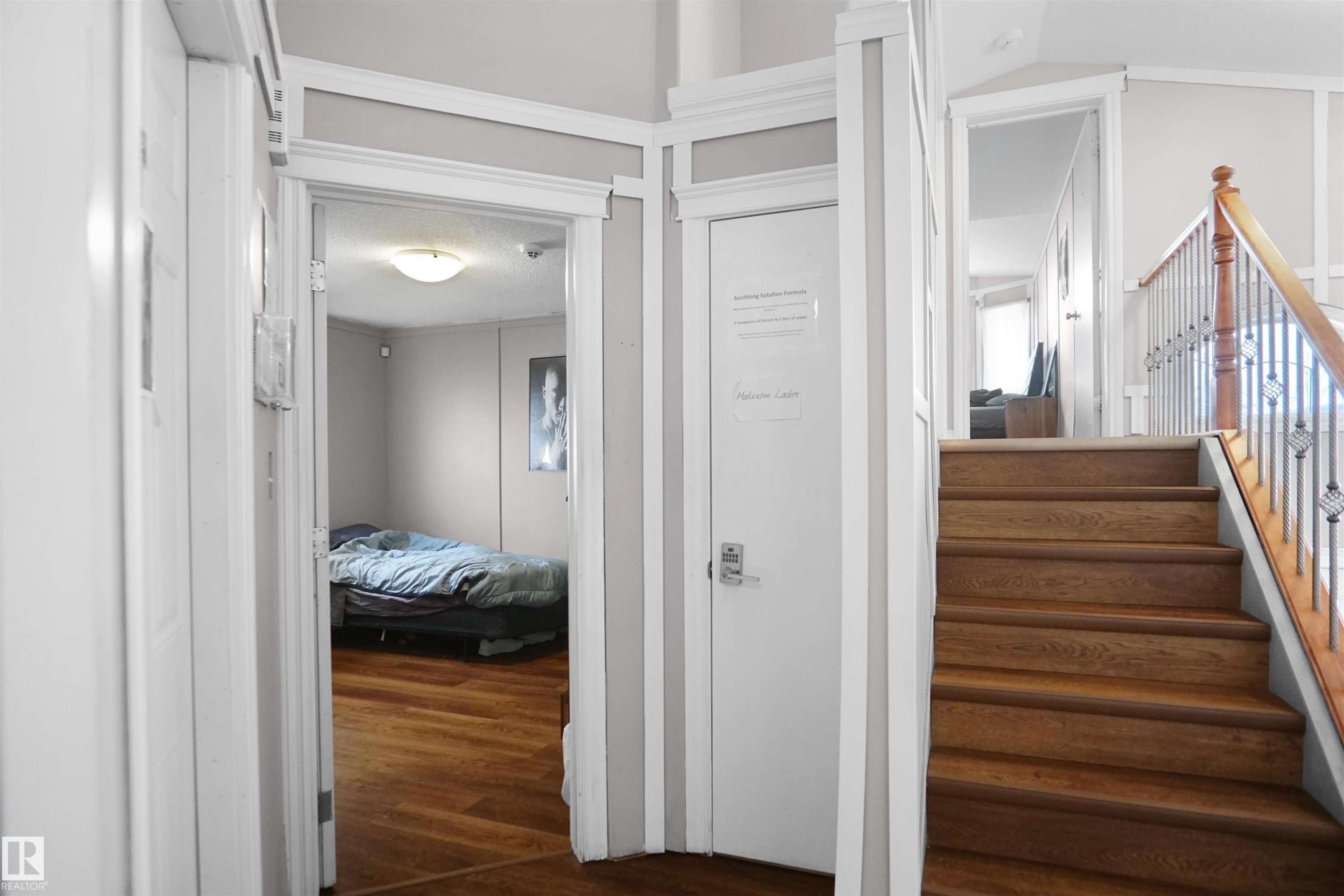 Wood-finish flooring extends from the hallway into an open room - 4816 155 Ave, Edmonton, AB