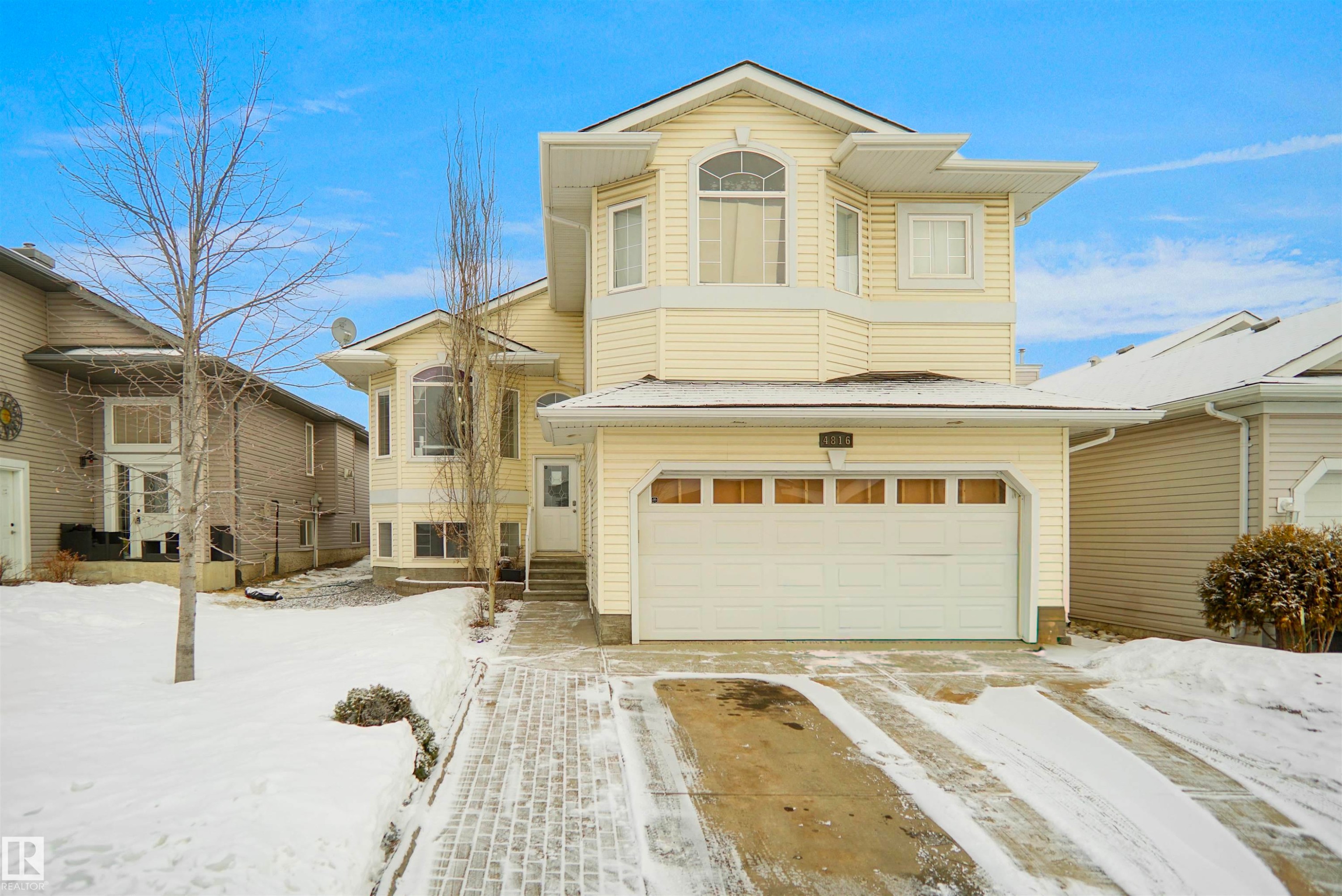 Two-story residence featuring light-colored siding and a gabled roofline - 4816 155 Ave, Edmonton, AB