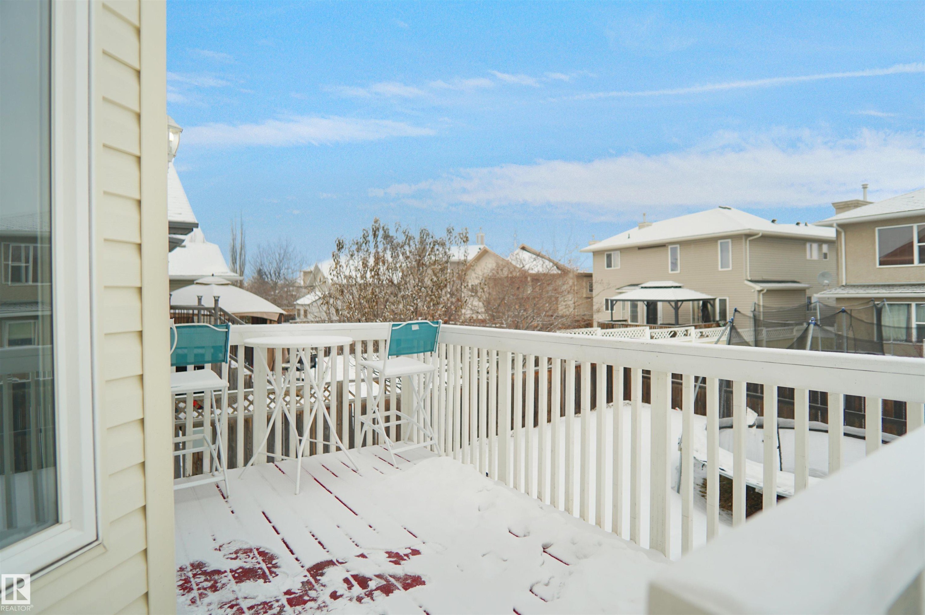 Upper-level exterior deck featuring white railing and siding - 4816 155 Ave, Edmonton, AB