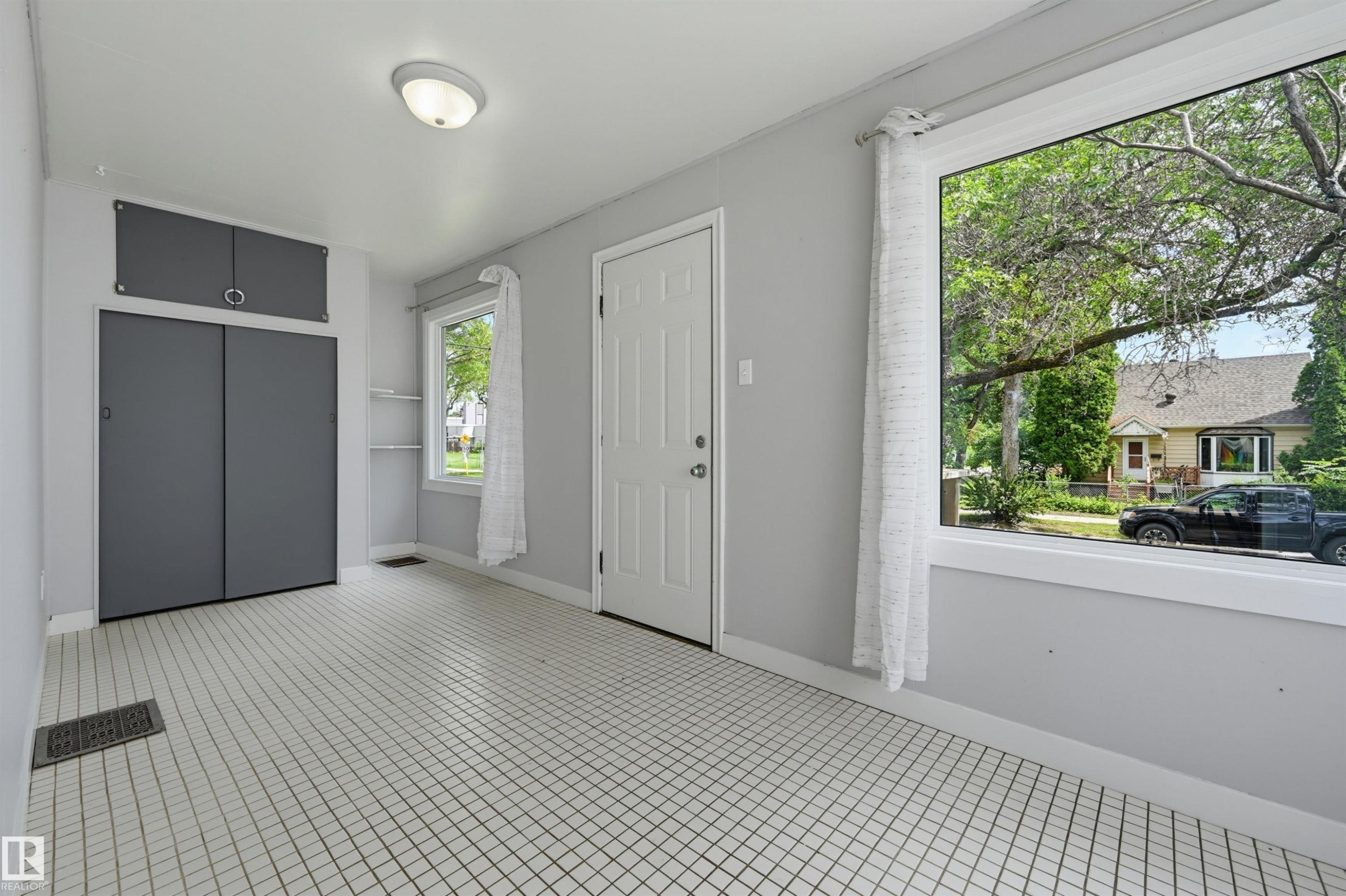 Bright room with grid-patterned floor tiling - 11450 71 Street Nw, Edmonton, AB