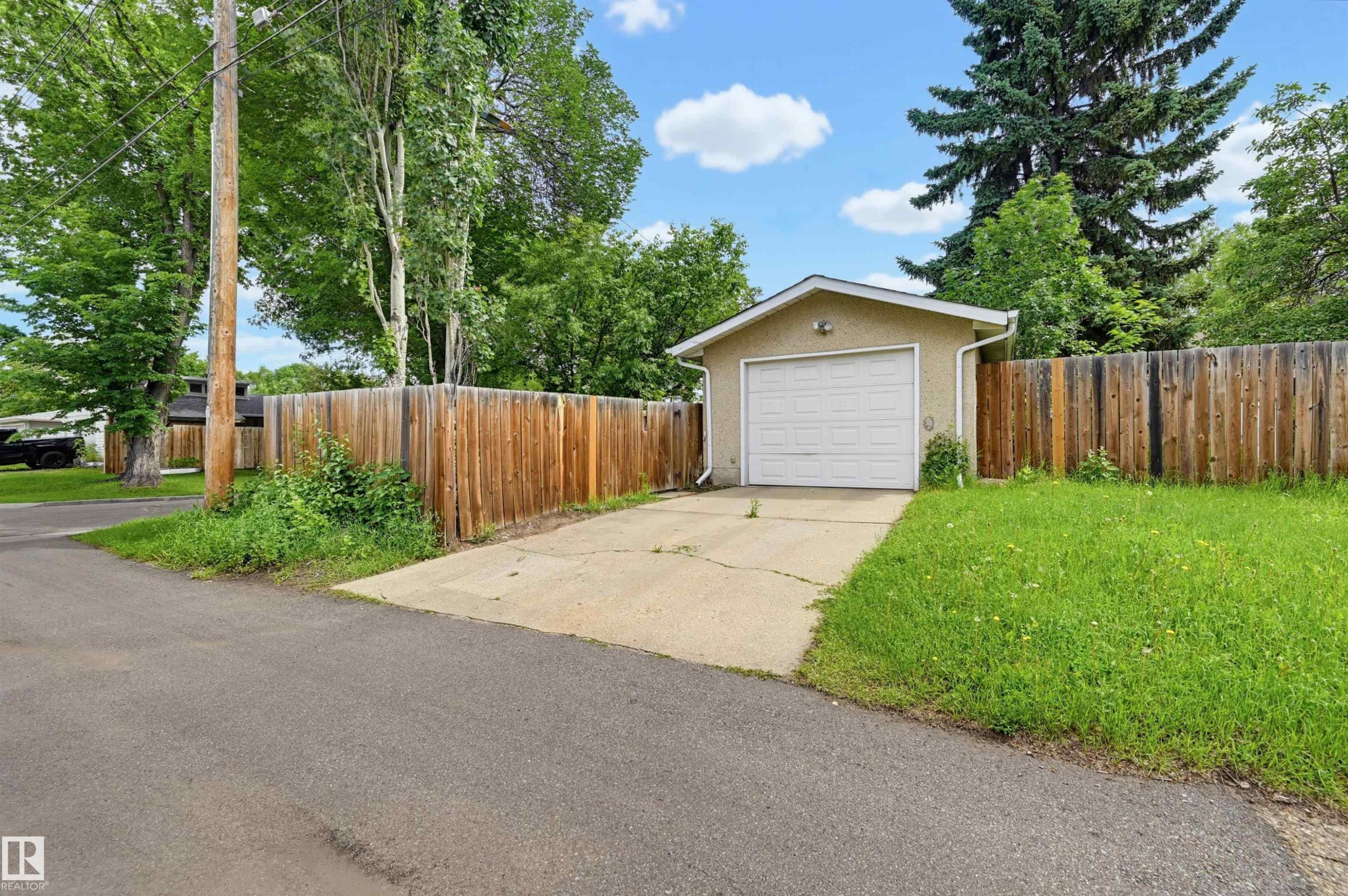 Detached garage with a white overhead door and stucco exterior - 11450 71 Street Nw, Edmonton, AB