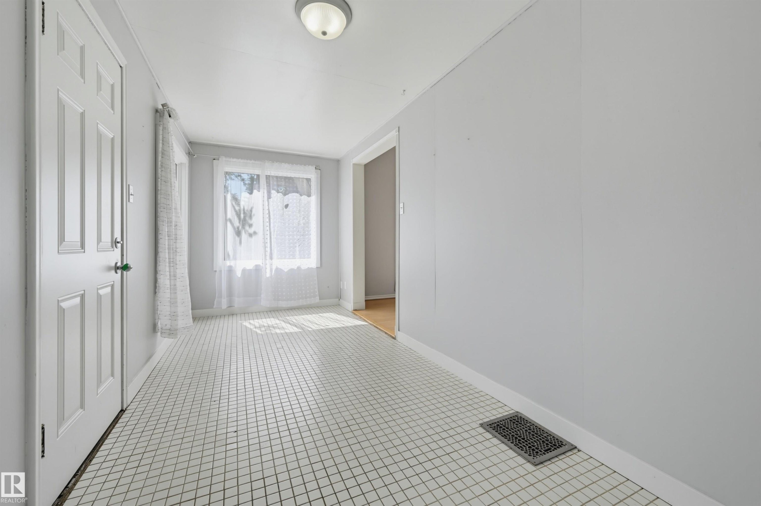 Entryway featuring white square tile flooring and light grey wall finishes - 11450 71 Street Nw, Edmonton, AB