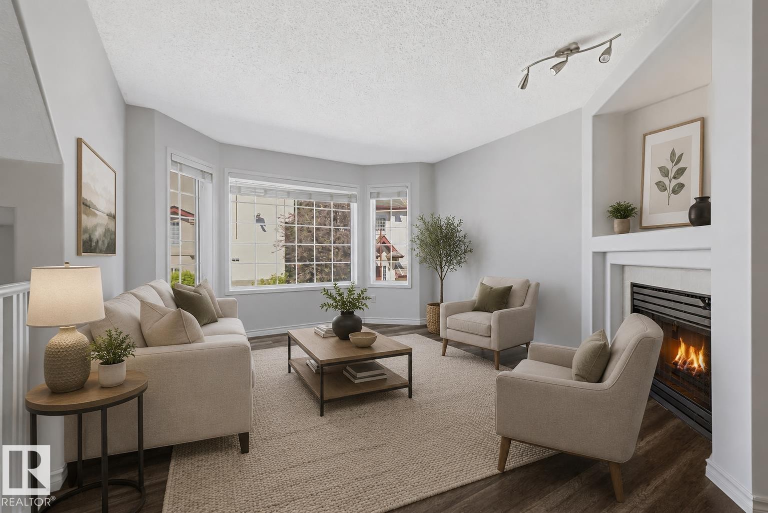 Living space featuring wood-finish flooring, a bay window, and a built-in fireplace with a white mantel and hearth - 6 1237 Carter Crest Road, Edmonton, AB