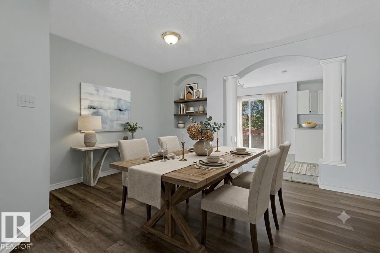 Dining area featuring wood-finish flooring, a contemporary ceiling light fixture, and light blue wall tones - 6 1237 Carter Crest Road, Edmonton, AB