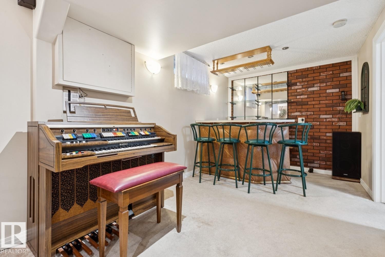 Entertainment space featuring a built-in wet bar with a mirrored backsplash, a brick accent wall, recessed lighting, and light-toned carpeting - 3015 131 Avenue, Edmonton, AB