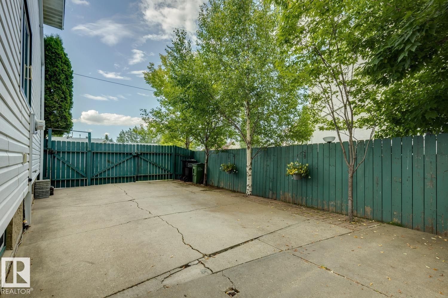 Paved concrete patio area with a high privacy fence - 3015 131 Avenue, Edmonton, AB
