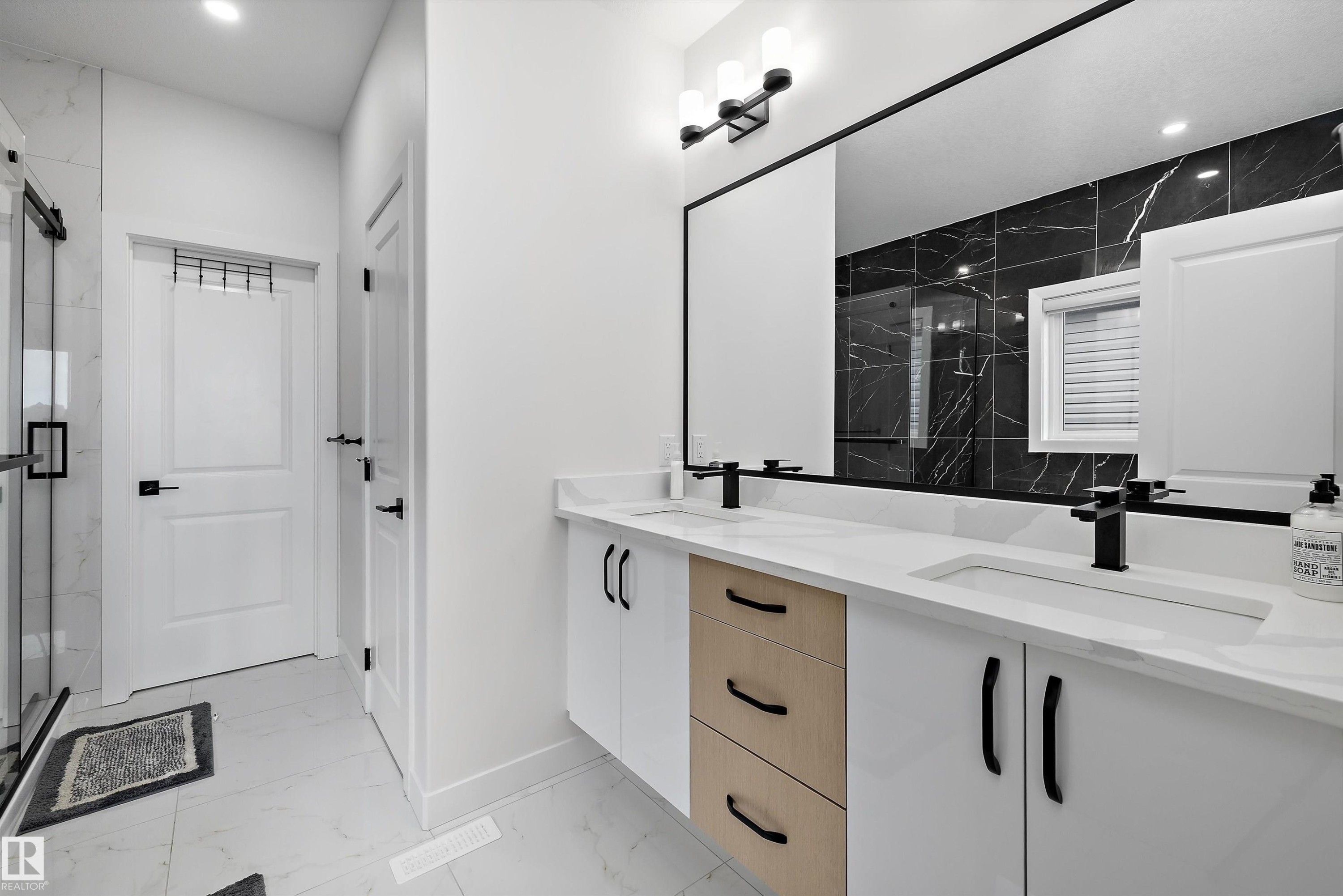 Double vanity with integrated sinks, quartz countertop, and matte black fixtures - 403 Pine Point, Leduc, AB