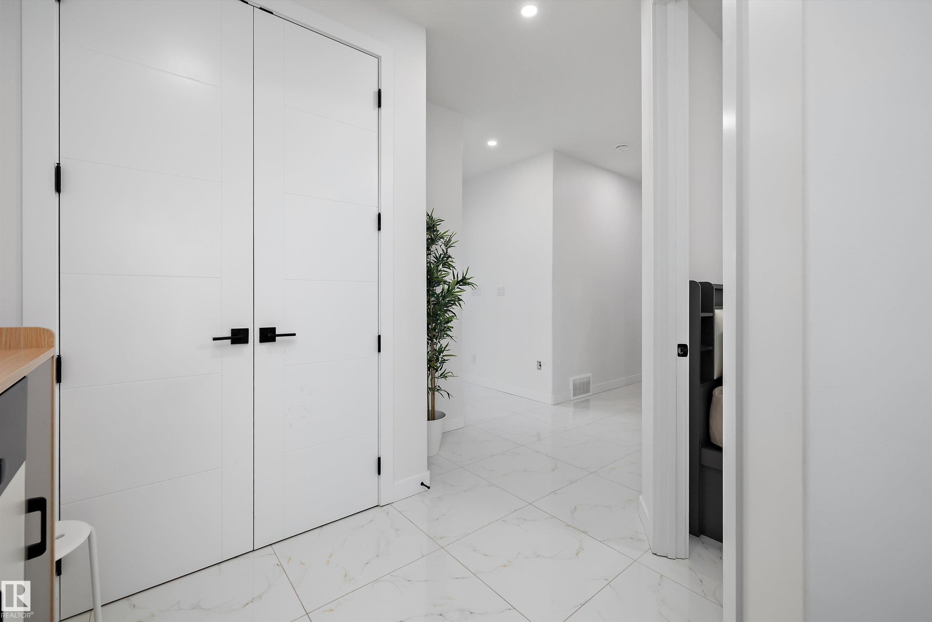 White paneled double doors with matte black hardware - 403 Pine Point, Leduc, AB