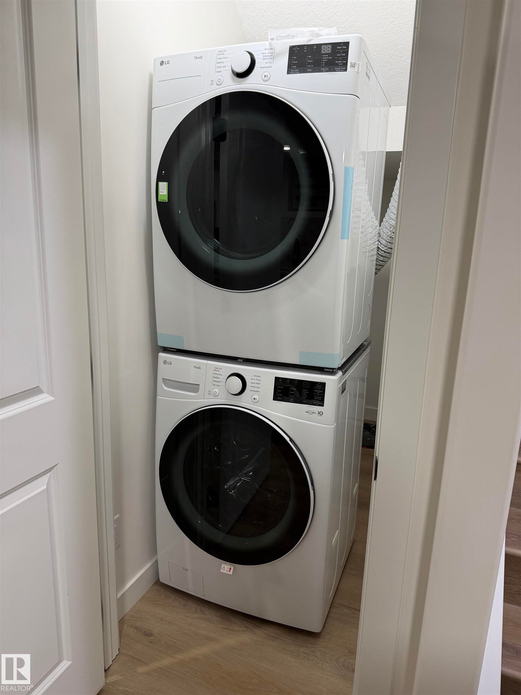 Dedicated laundry area featuring a stacked washer and dryer unit - 403 Pine Point, Leduc, AB