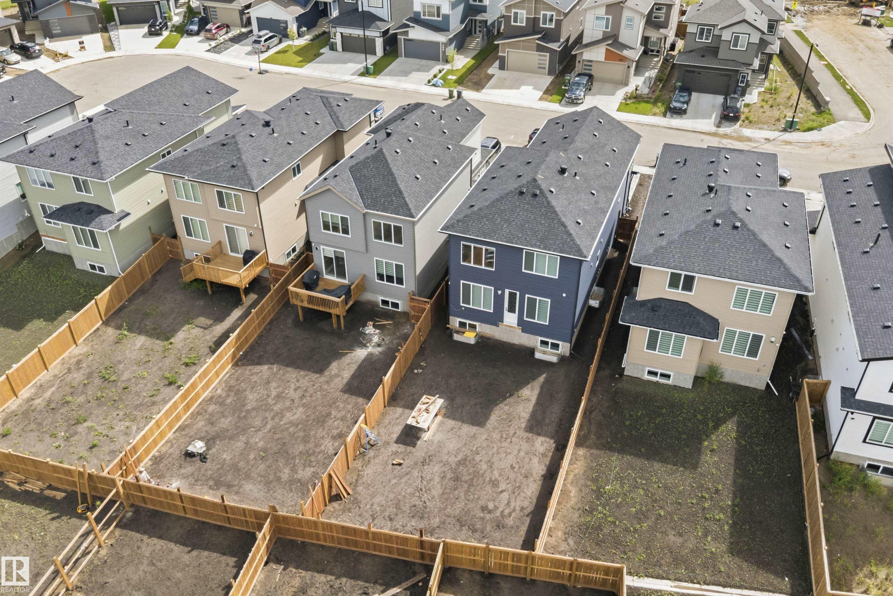 Aerial view showcasing multiple properties with undeveloped rear yards and privacy fencing - 403 Pine Point, Leduc, AB