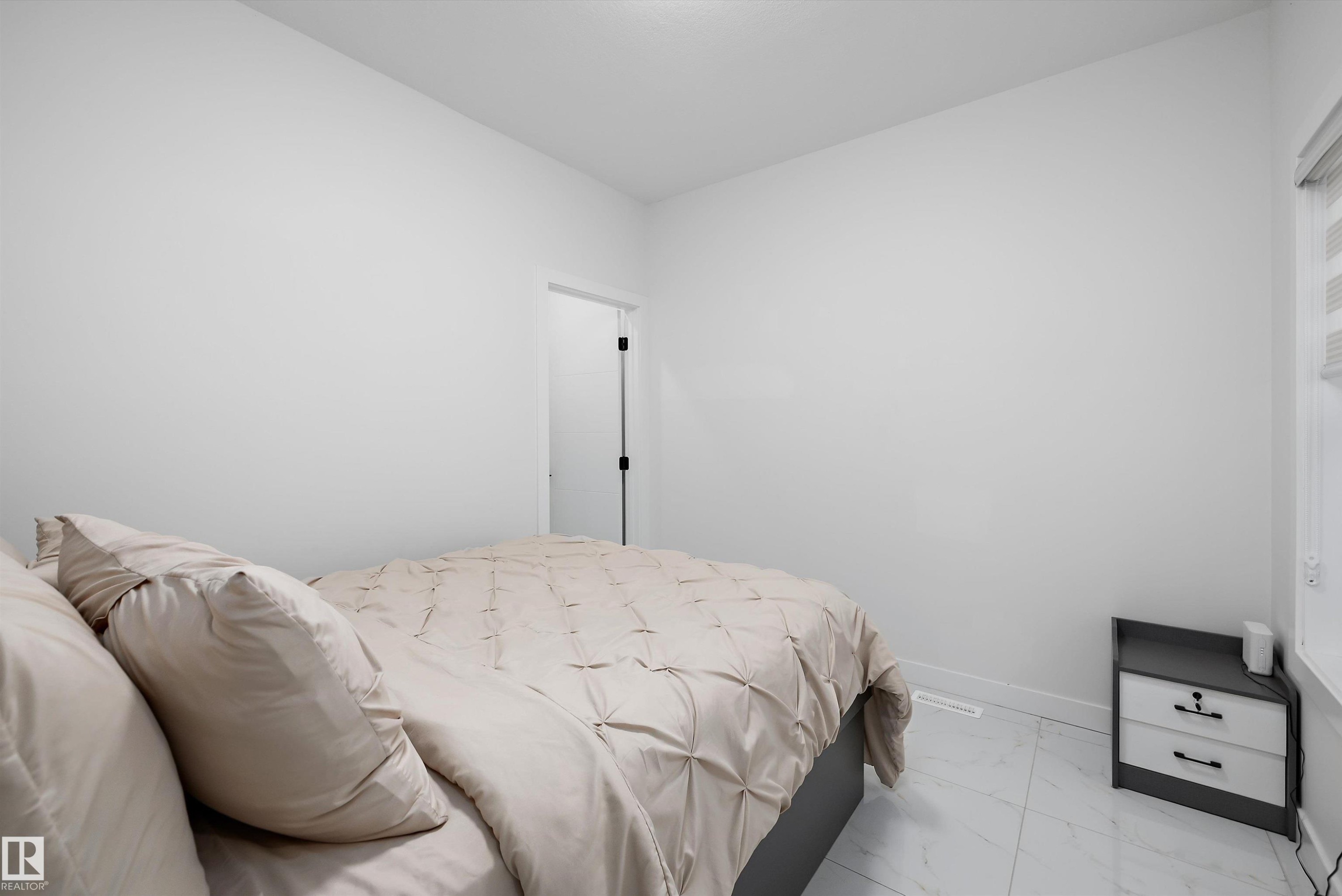 Bright room featuring white walls, white tile flooring, a window with horizontal blinds, and a white baseboard - 403 Pine Point, Leduc, AB