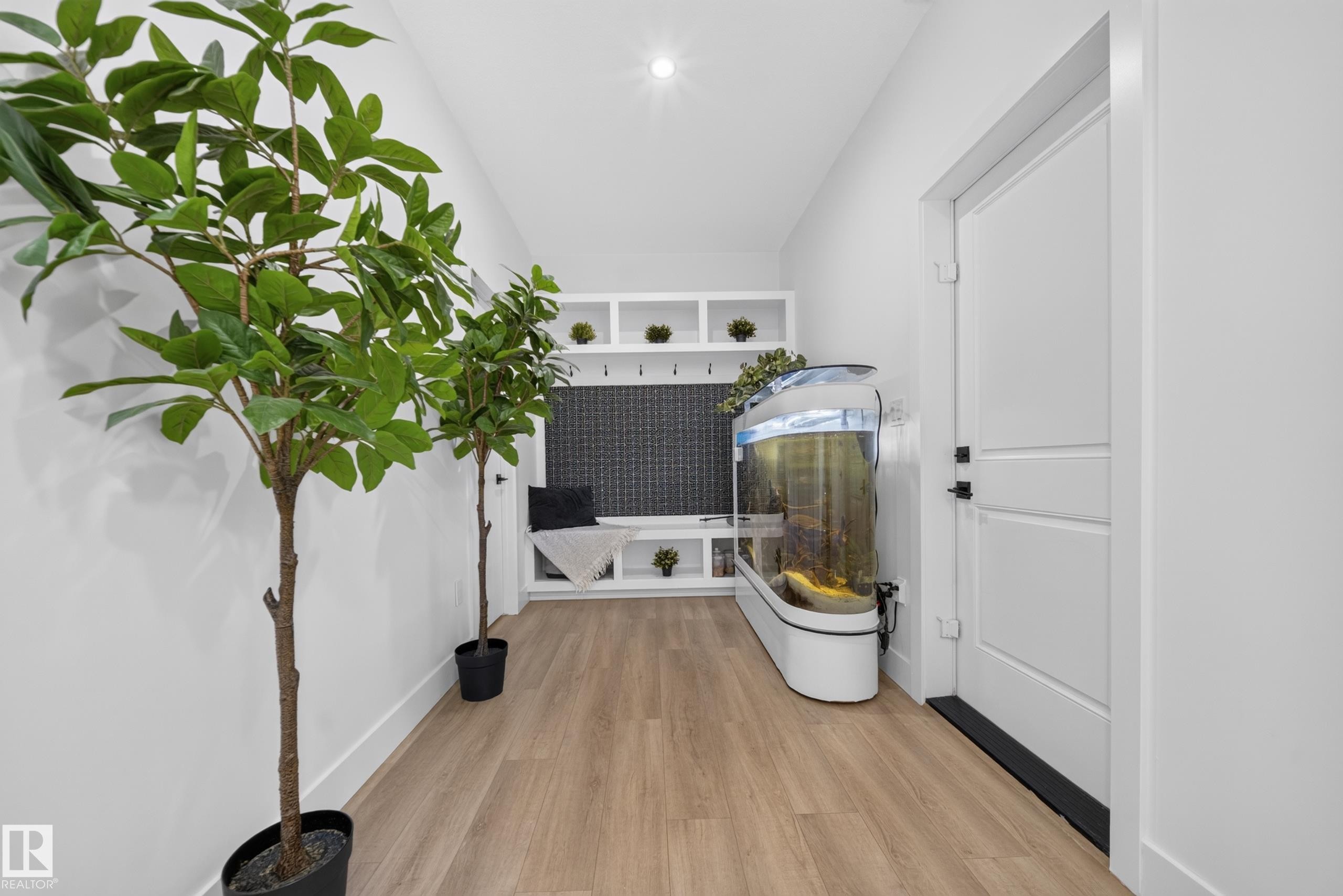 Entryway featuring wood-finish flooring and a built-in storage bench with shelving - 626 Astoria Way, Devon, AB