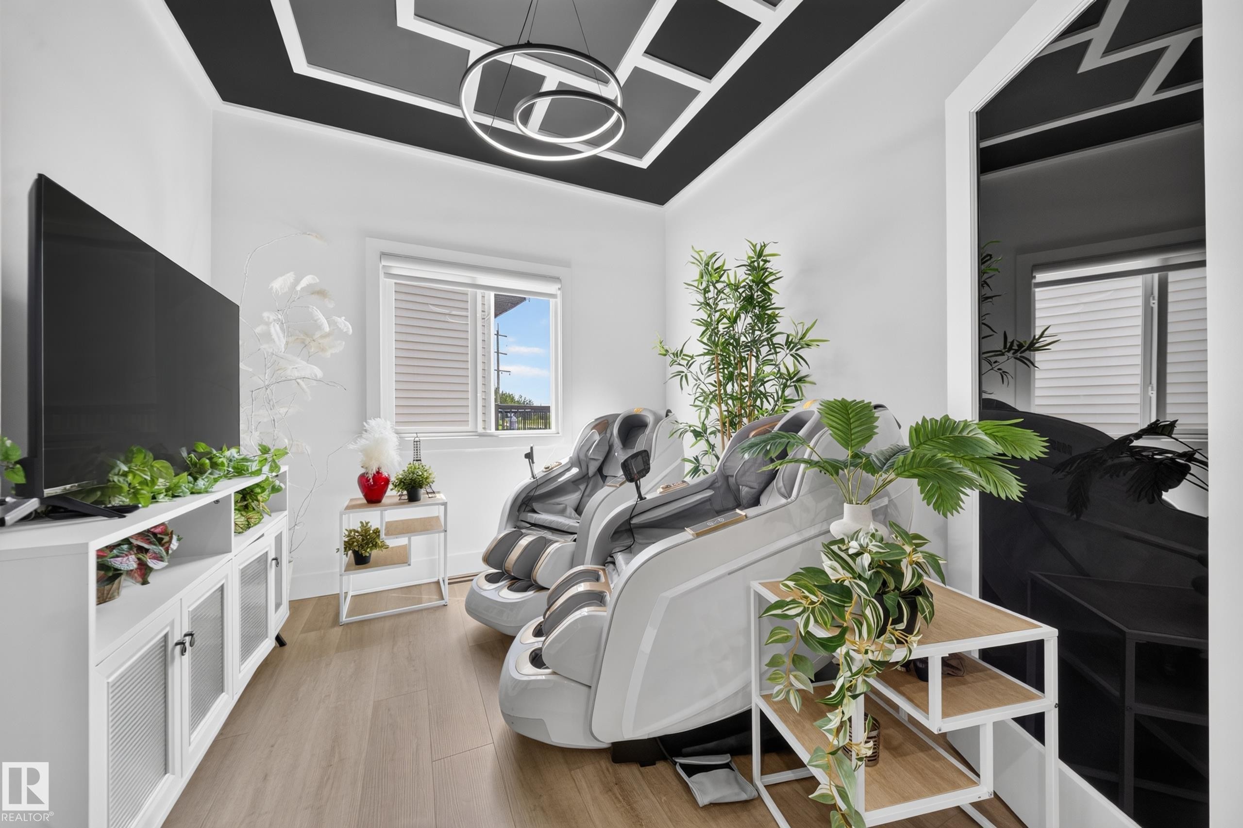 Room featuring a distinctive black and white geometric ceiling design with a contemporary circular light fixture - 626 Astoria Way, Devon, AB