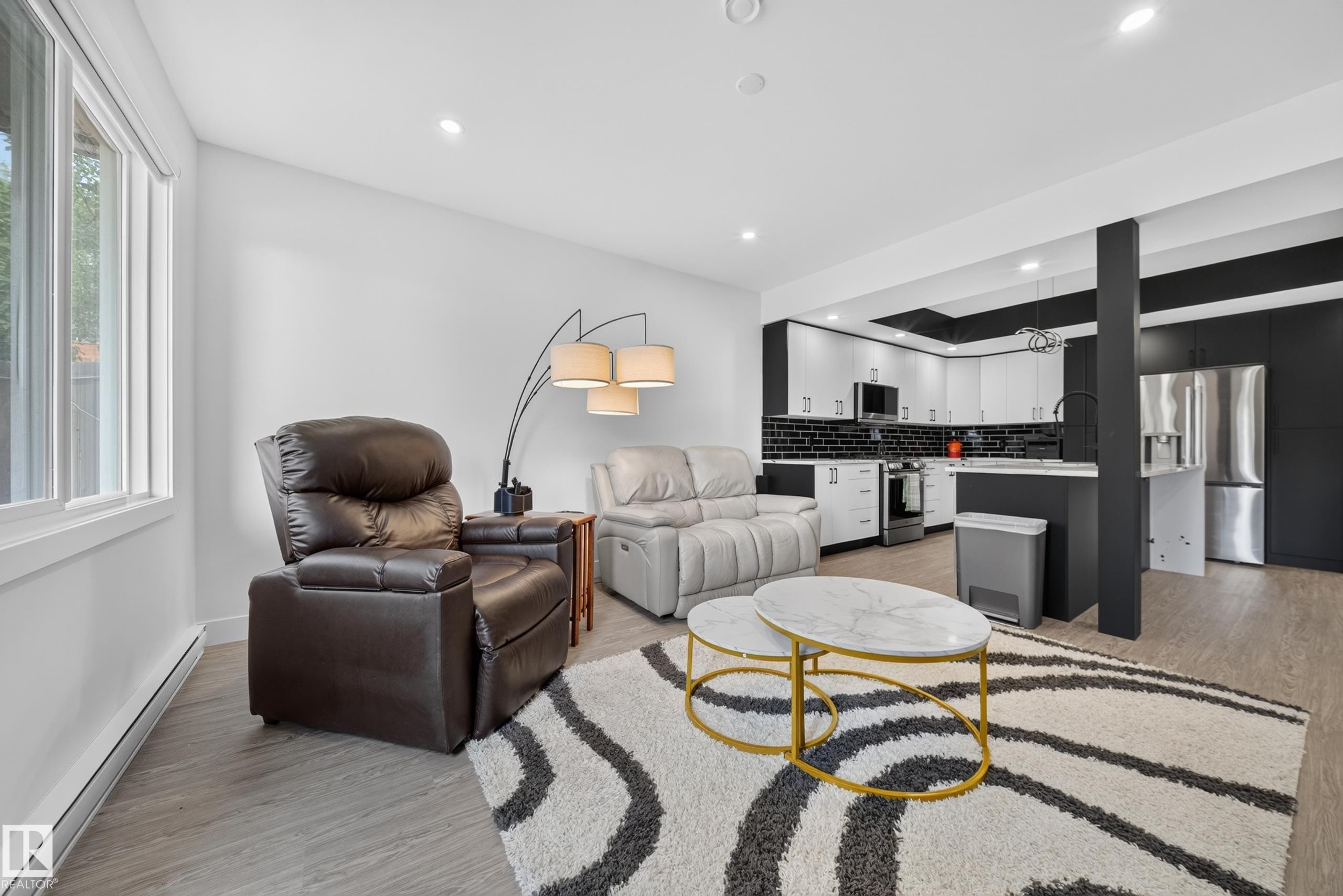 Open-concept living area featuring wood-finish flooring, recessed lighting, and a window with white trim - 626 Astoria Way, Devon, AB