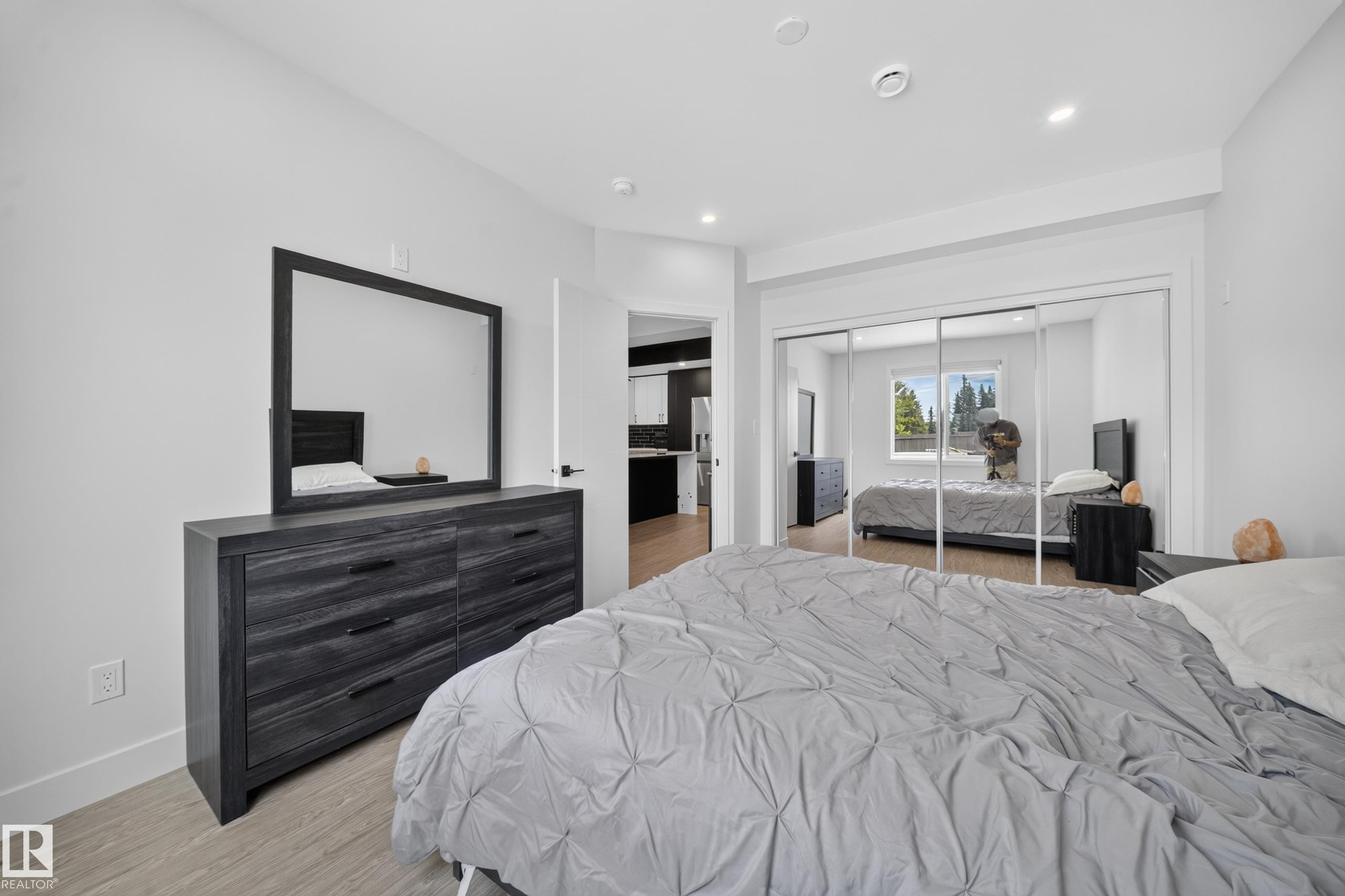 Recessed lighting illuminates this bright room featuring wood-finish flooring and a spacious mirrored closet - 626 Astoria Way, Devon, AB