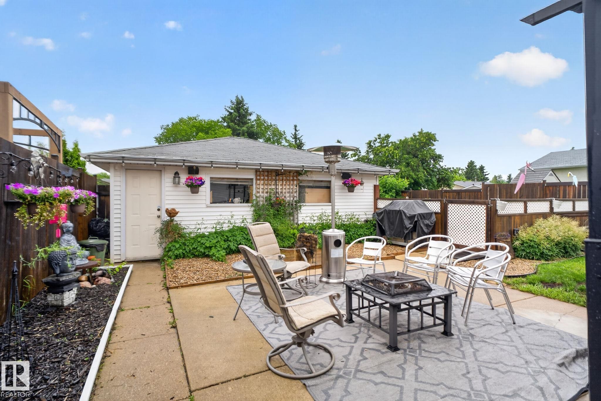 Paved patio area featuring an outdoor rug, surrounded by a wood fence with lattice accents - 7539 149A Avenue Nw, Edmonton, AB - Outdoor