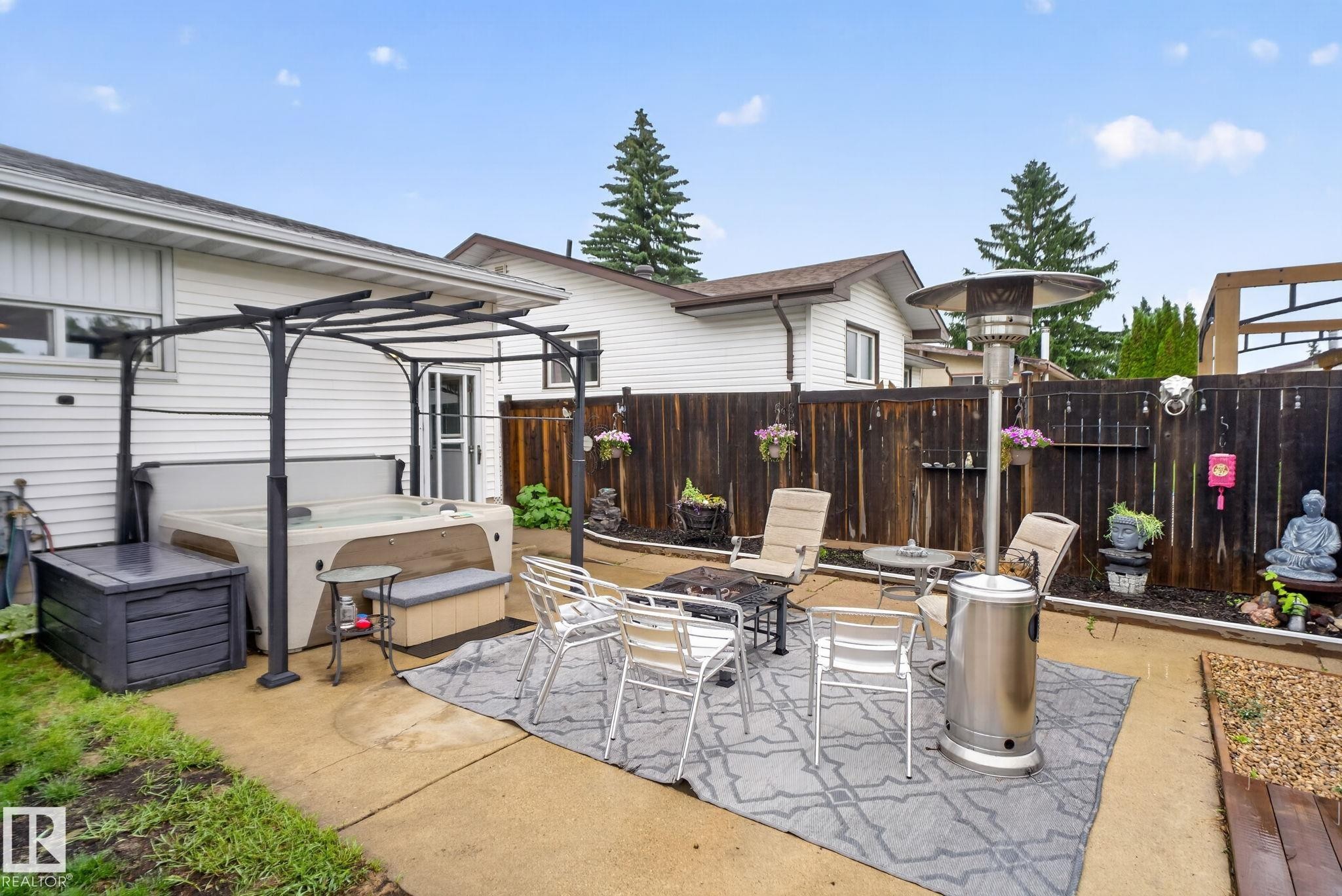 Backyard patio featuring a built-in hot tub beneath a metal pergola - 7539 149A Avenue Nw, Edmonton, AB - Outdoor With Deck Patio Veranda With Exterior