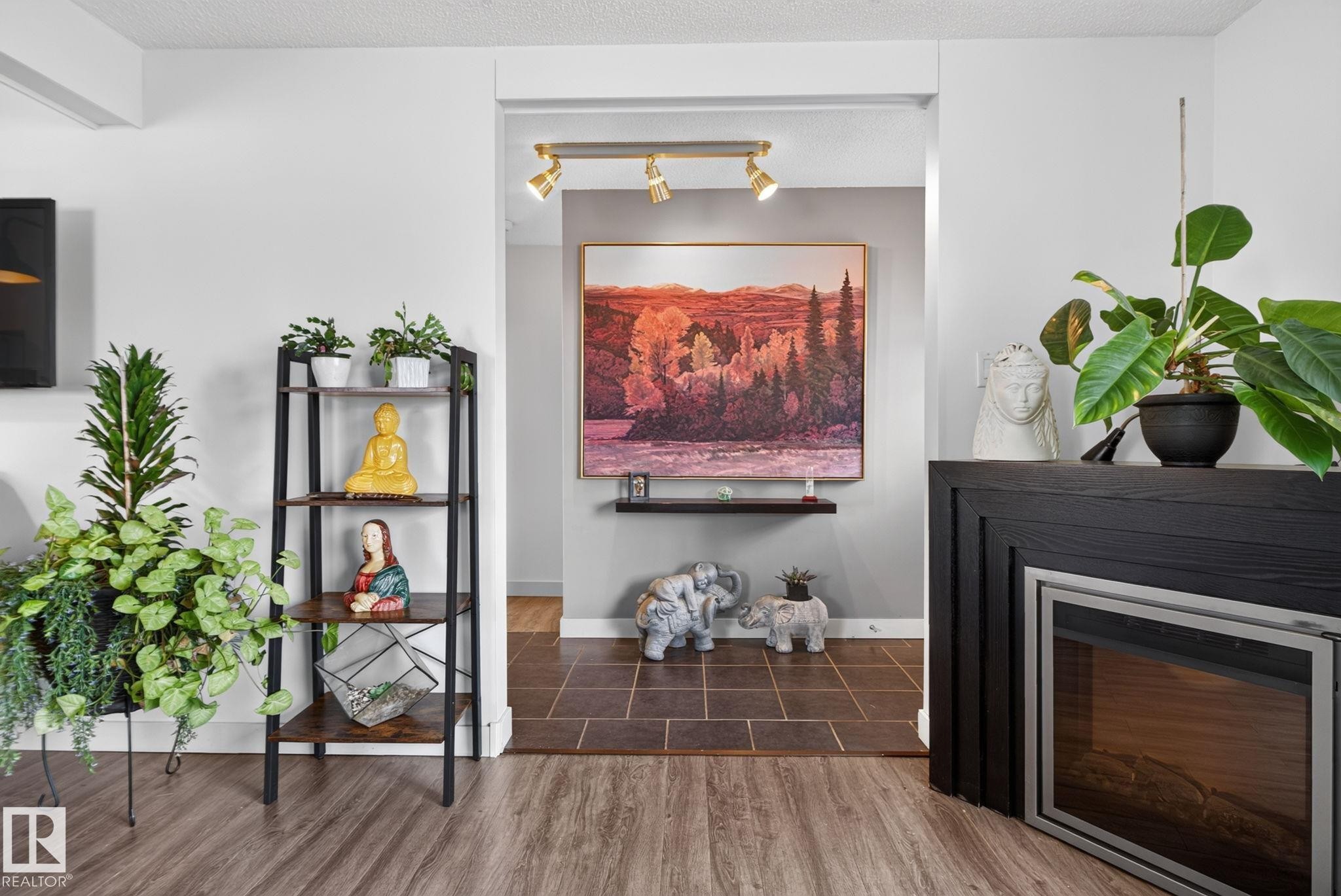 Electric fireplace with a dark wood surround and a stainless steel trim - 7539 149A Avenue Nw, Edmonton, AB - Indoor With Fireplace