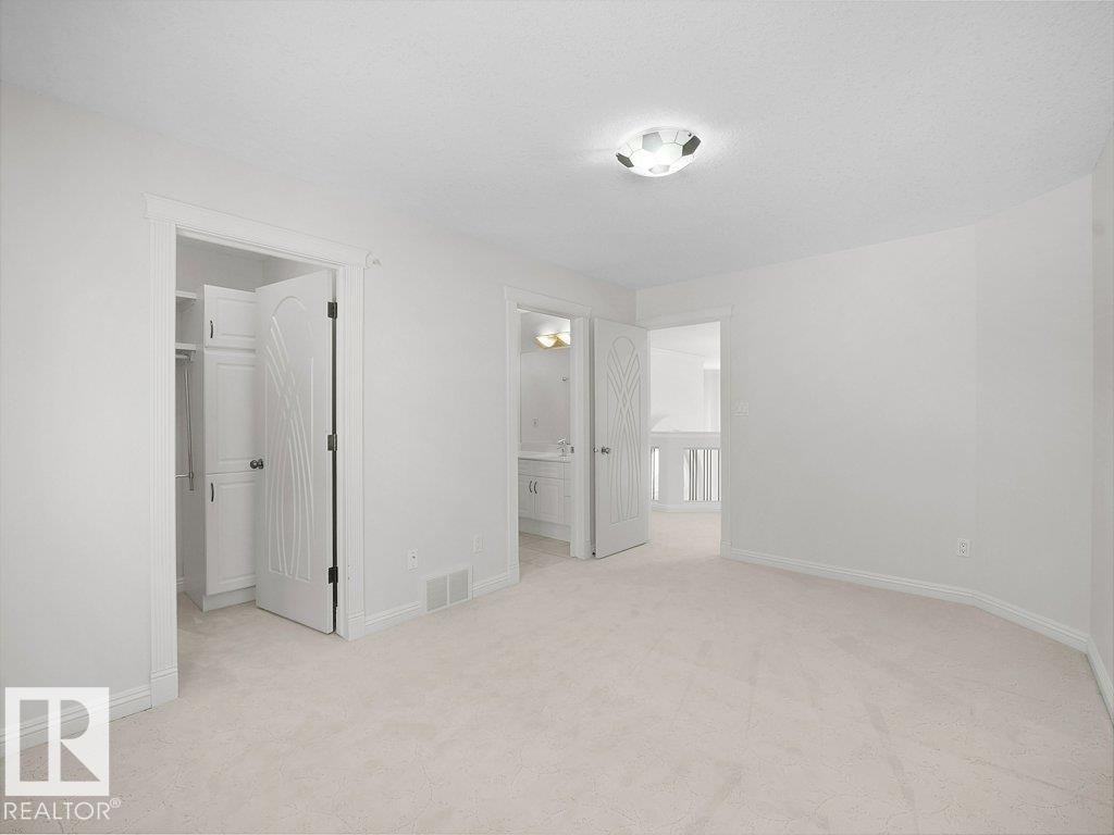 Light-toned wall-to-wall carpeting and neutral wall finishes - 2423 Tegler Green, Edmonton, AB