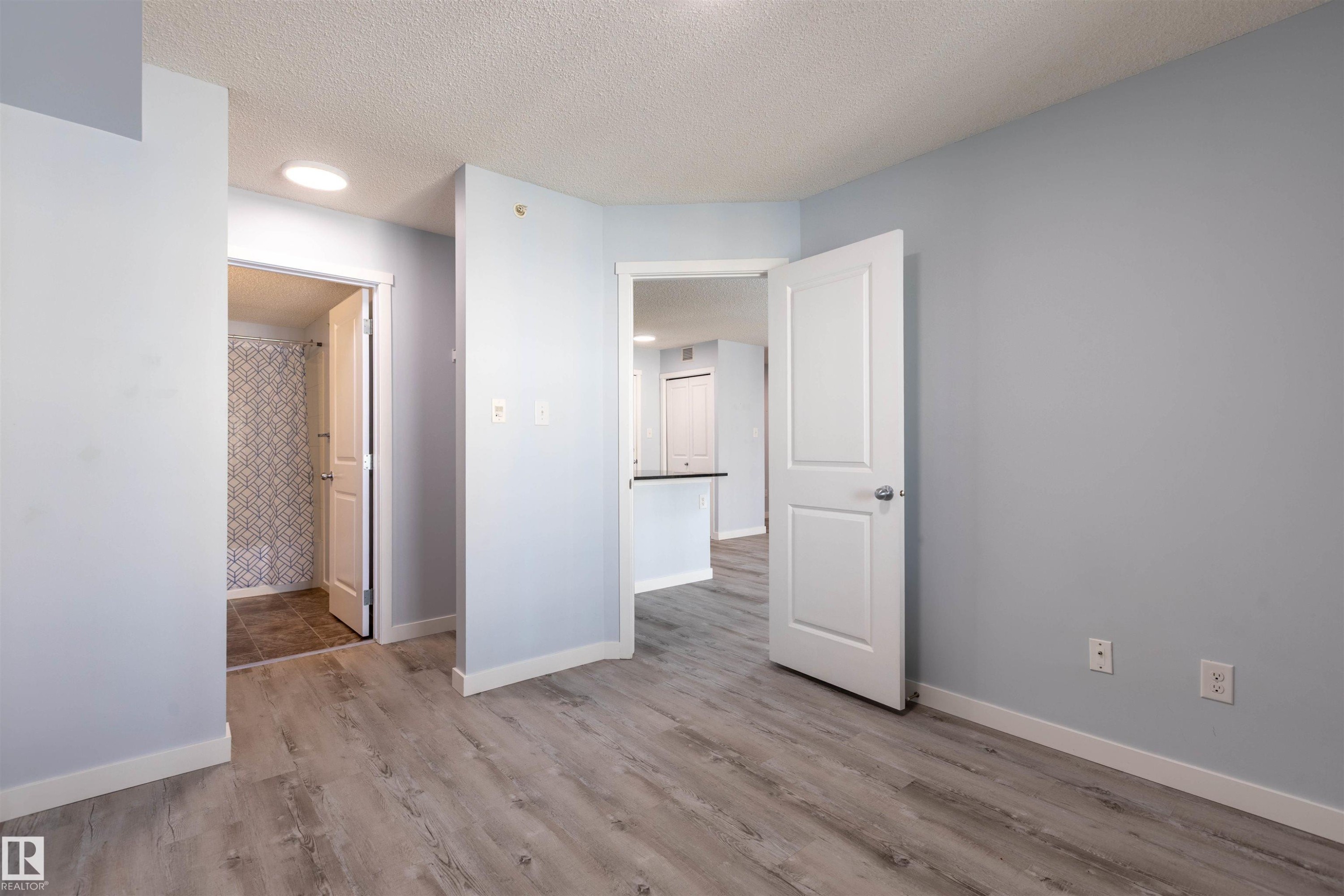 Light blue walls with white trim and wood-finish flooring throughout - 403 25 Element Dr, St. Albert, AB - Indoor Photo Showing Other Room