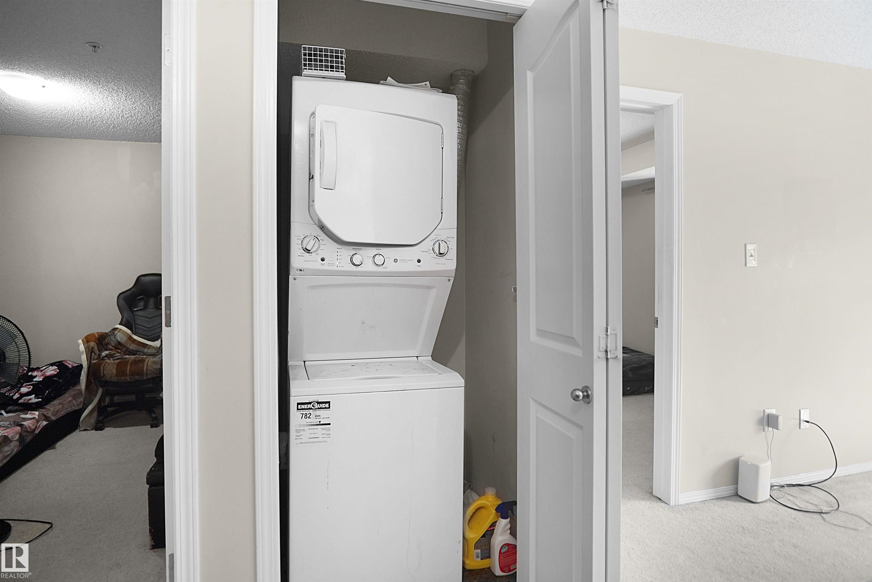 Dedicated laundry area featuring a white stacked washer and dryer unit - 215 1070 Mcconachie Blvd, Edmonton, AB