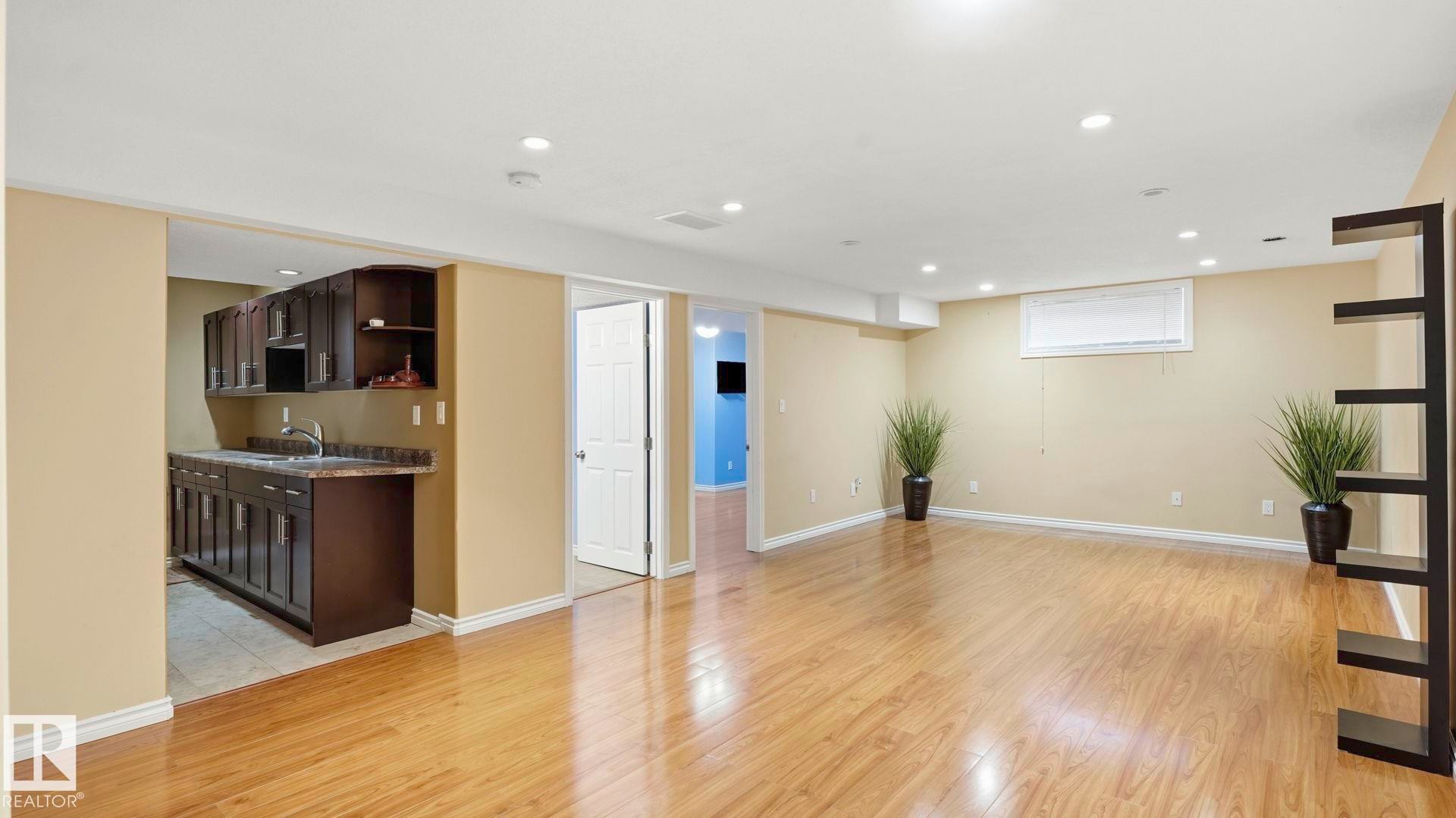 Spacious room featuring wood-finish flooring, recessed lighting, and a window - 3591 Mclean Crescent, Edmonton, AB