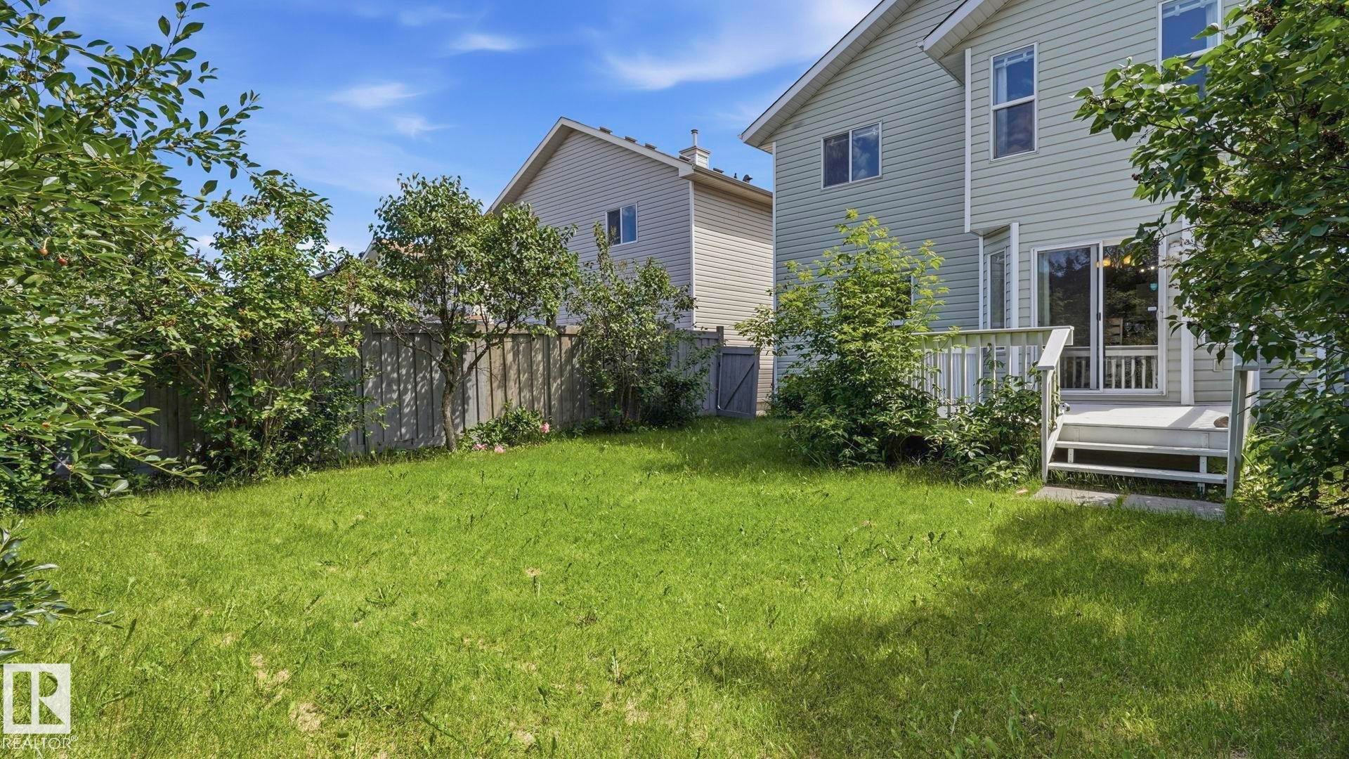 Expansive backyard featuring a manicured lawn, wood privacy fence, and mature perimeter trees - 3591 Mclean Crescent, Edmonton, AB