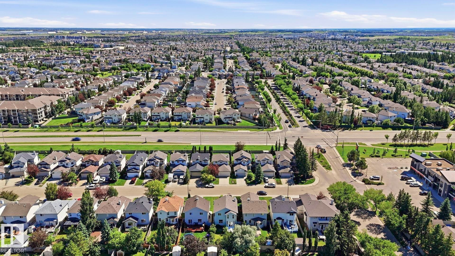 Expansive aerial perspective showcasing a developed residential area with numerous single-family homes, mature landscaping, and an organized street grid - 3591 Mclean Crescent, Edmonton, AB