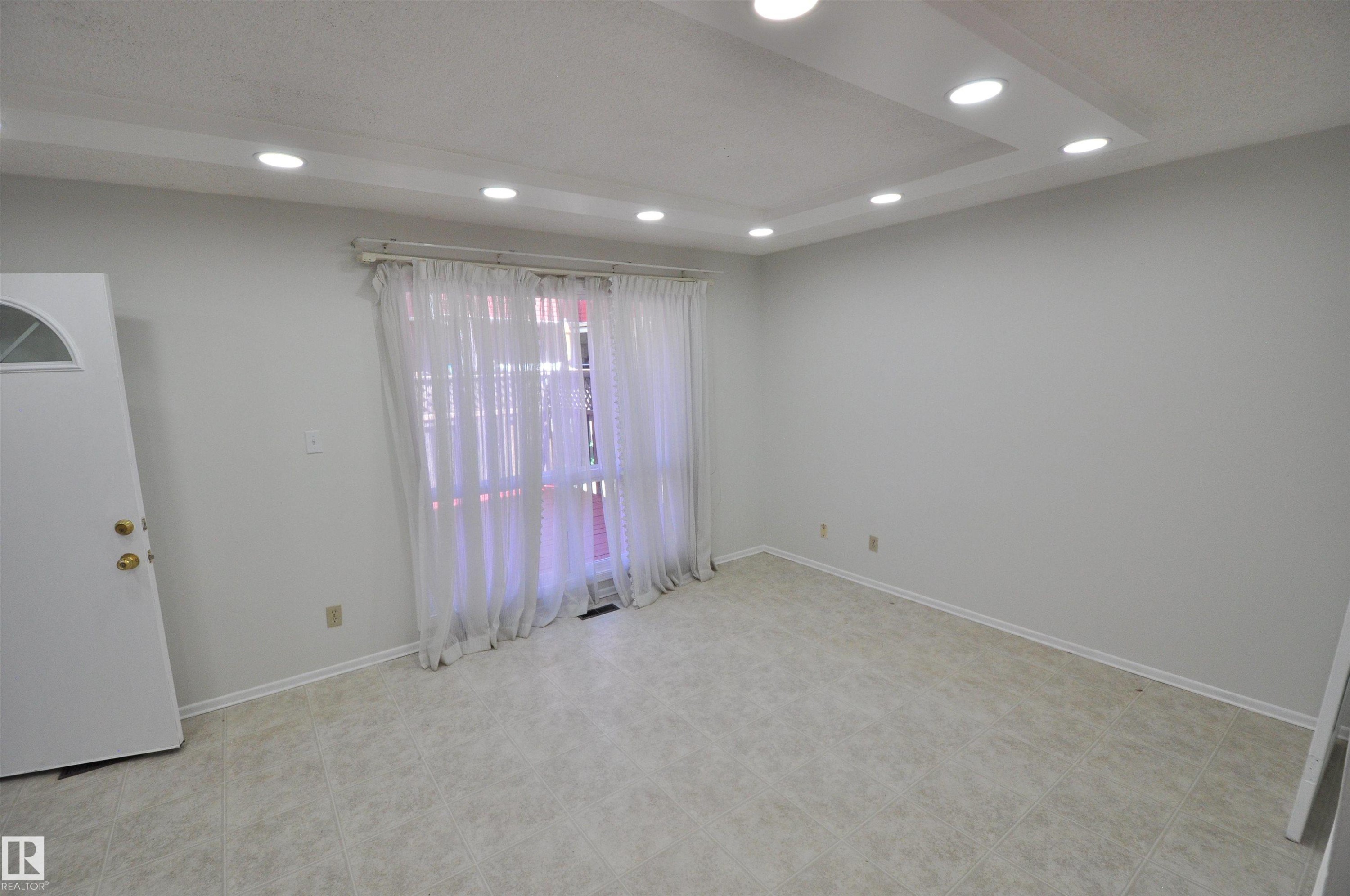 Recessed lighting in a tray ceiling, light-toned walls, and tile flooring - 617 Millbourne Road E, Edmonton, AB