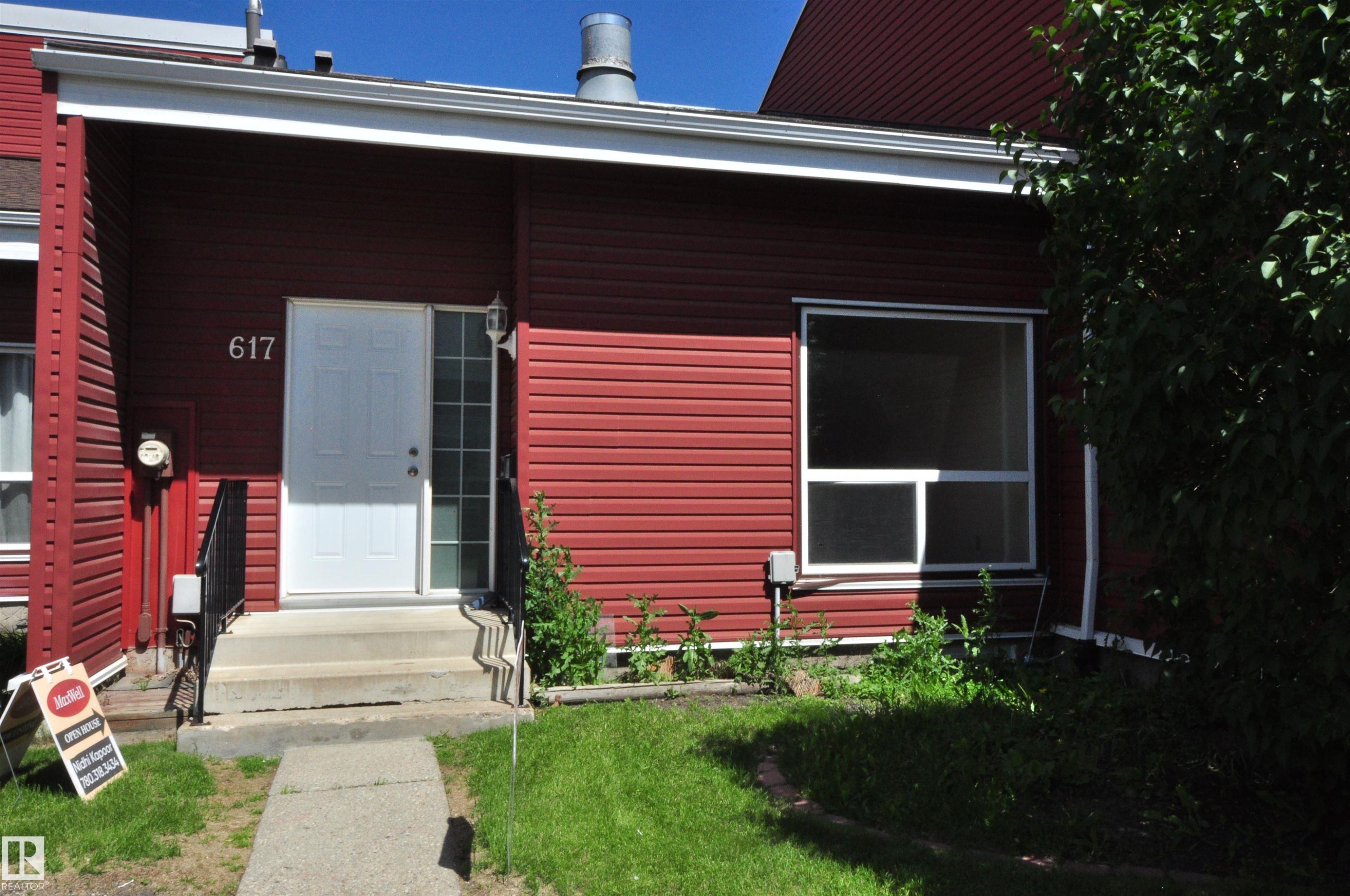 Red horizontal siding exterior with white trim, a white entry door, and a full-light sidelight - 617 Millbourne Road E, Edmonton, AB