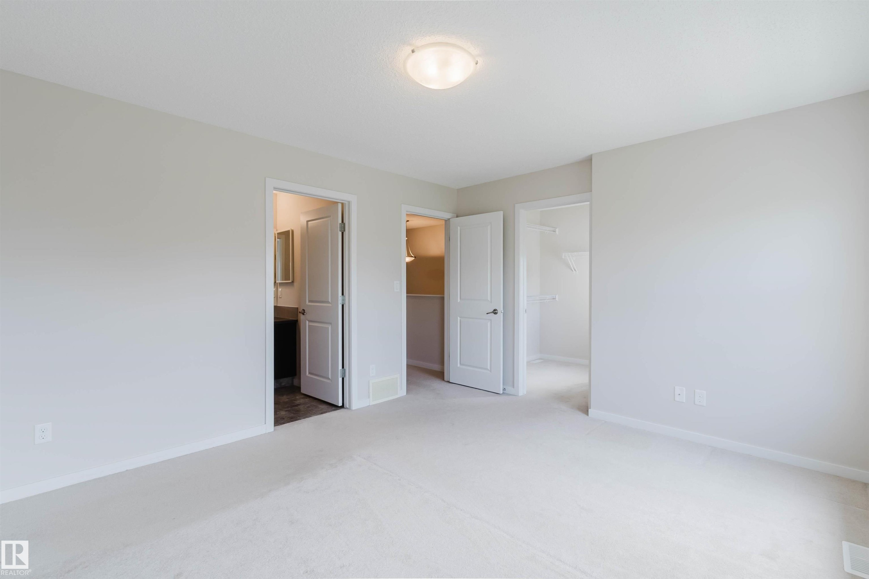 Spacious room featuring light-toned carpeting, neutral wall paint, and a semi-flush mount ceiling light - 636 Mcdonough Link Link, Edmonton, AB