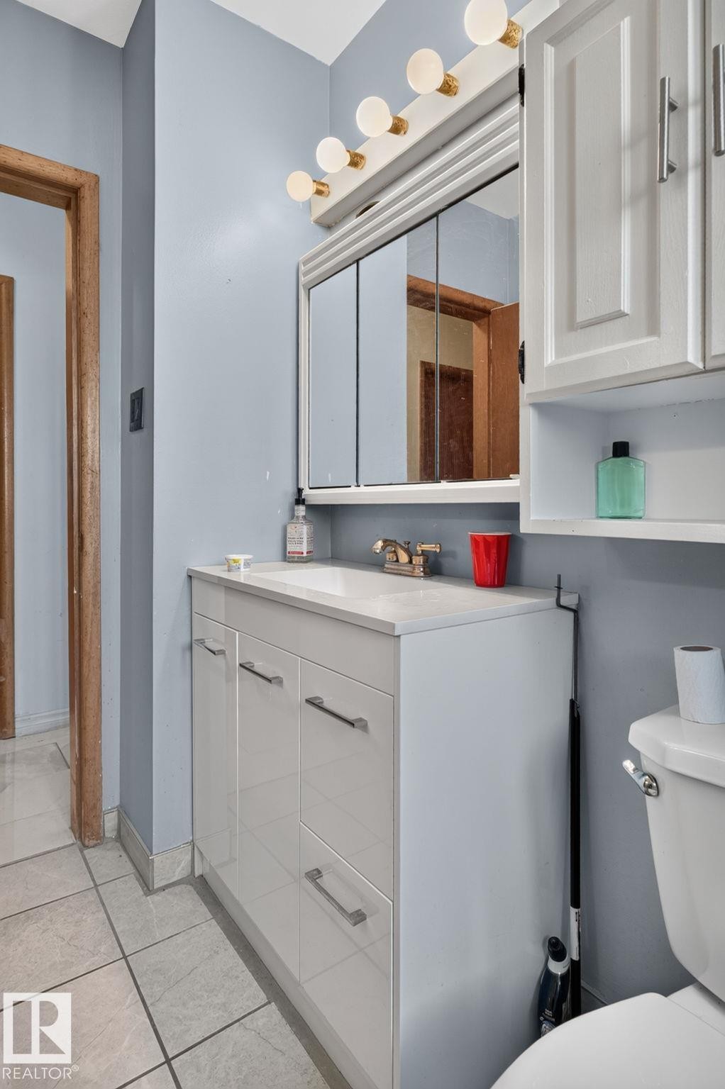 Bathroom vanity with a white countertop and base cabinetry featuring brushed nickel hardware - 12238 48 Street, Edmonton, AB