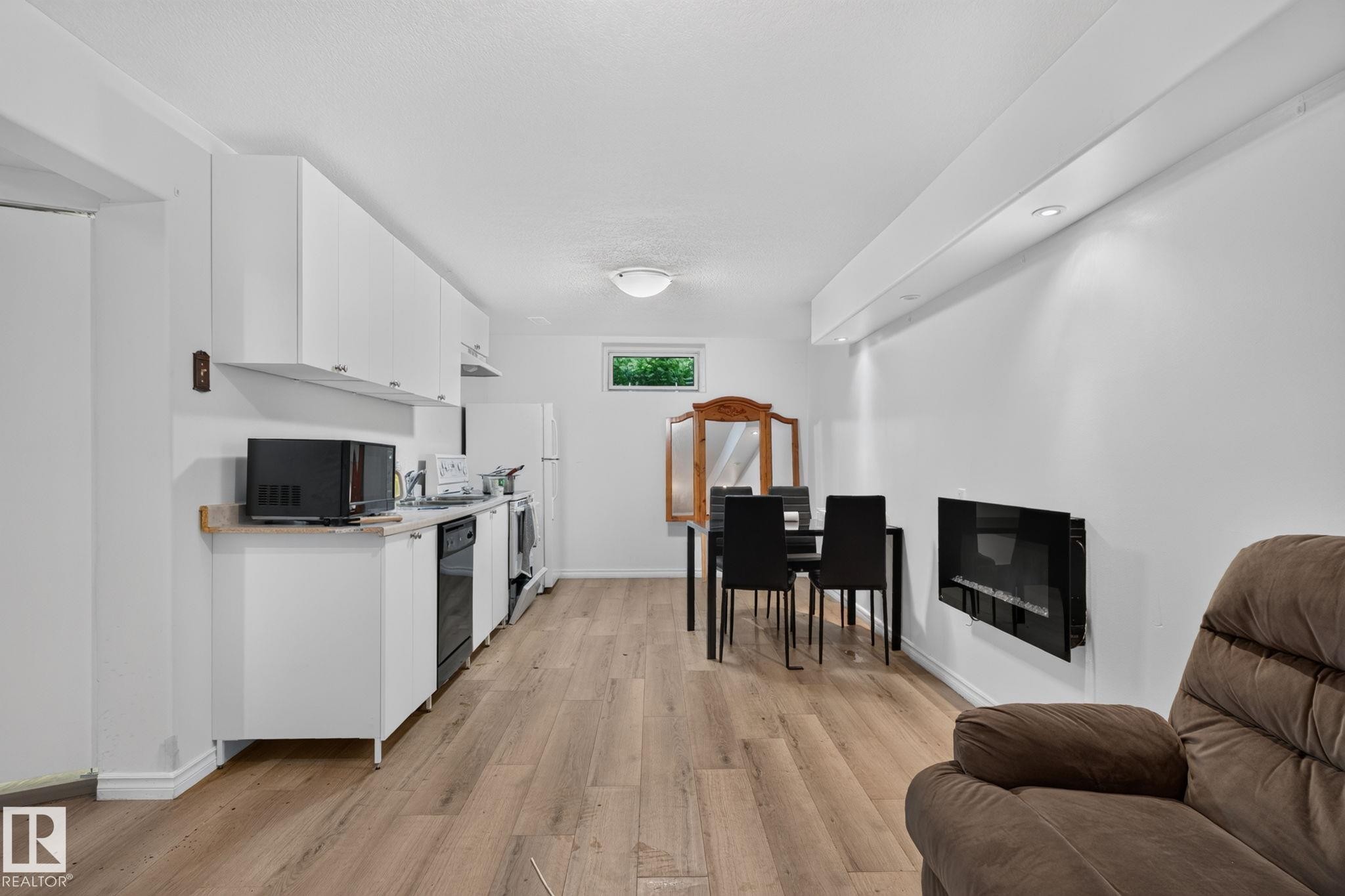 Kitchenette with white cabinetry, light-toned countertops, and black appliances - 12238 48 Street, Edmonton, AB