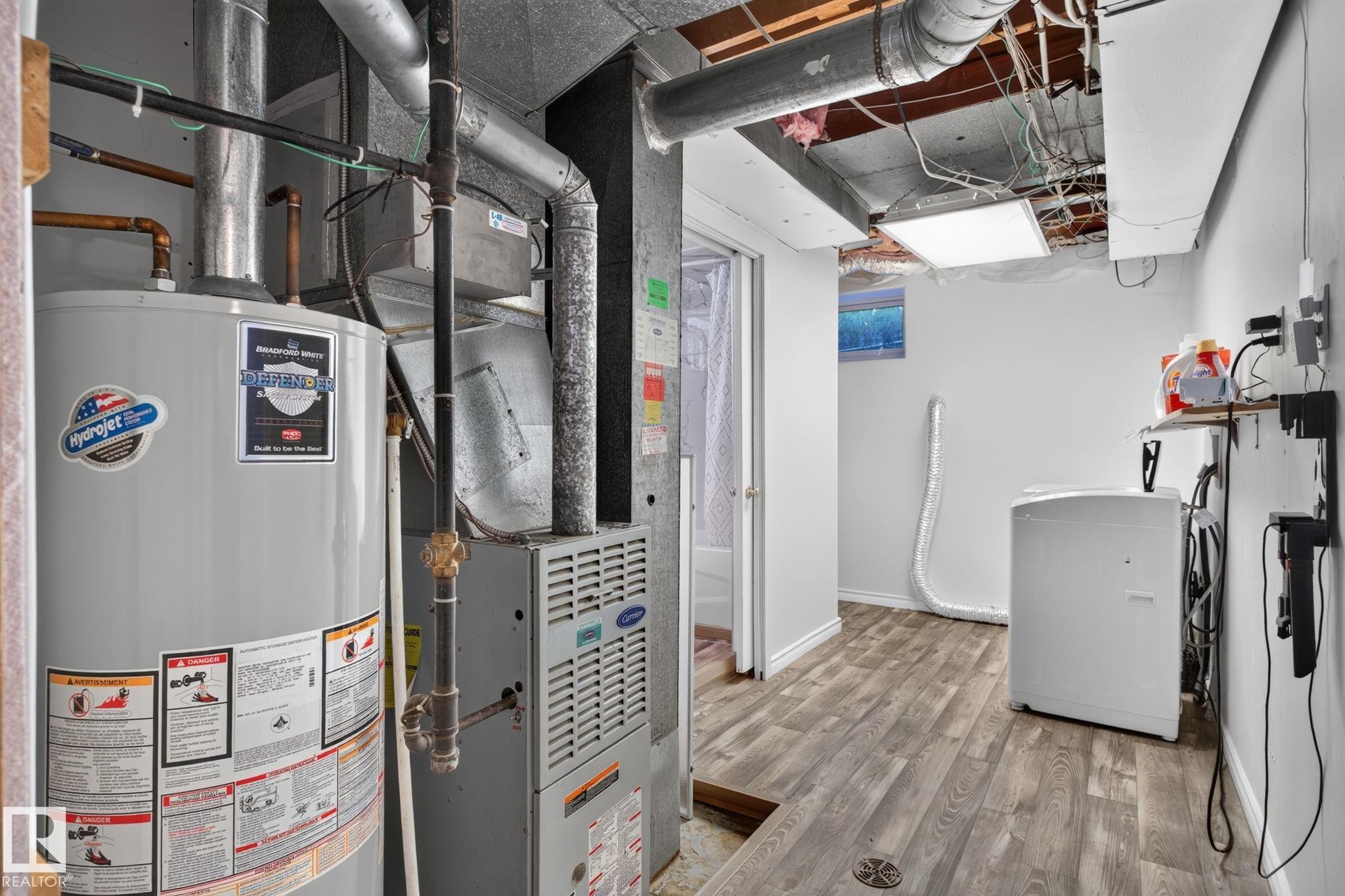 Dedicated utility space featuring a water heater, furnace, and washer - 12238 48 Street, Edmonton, AB